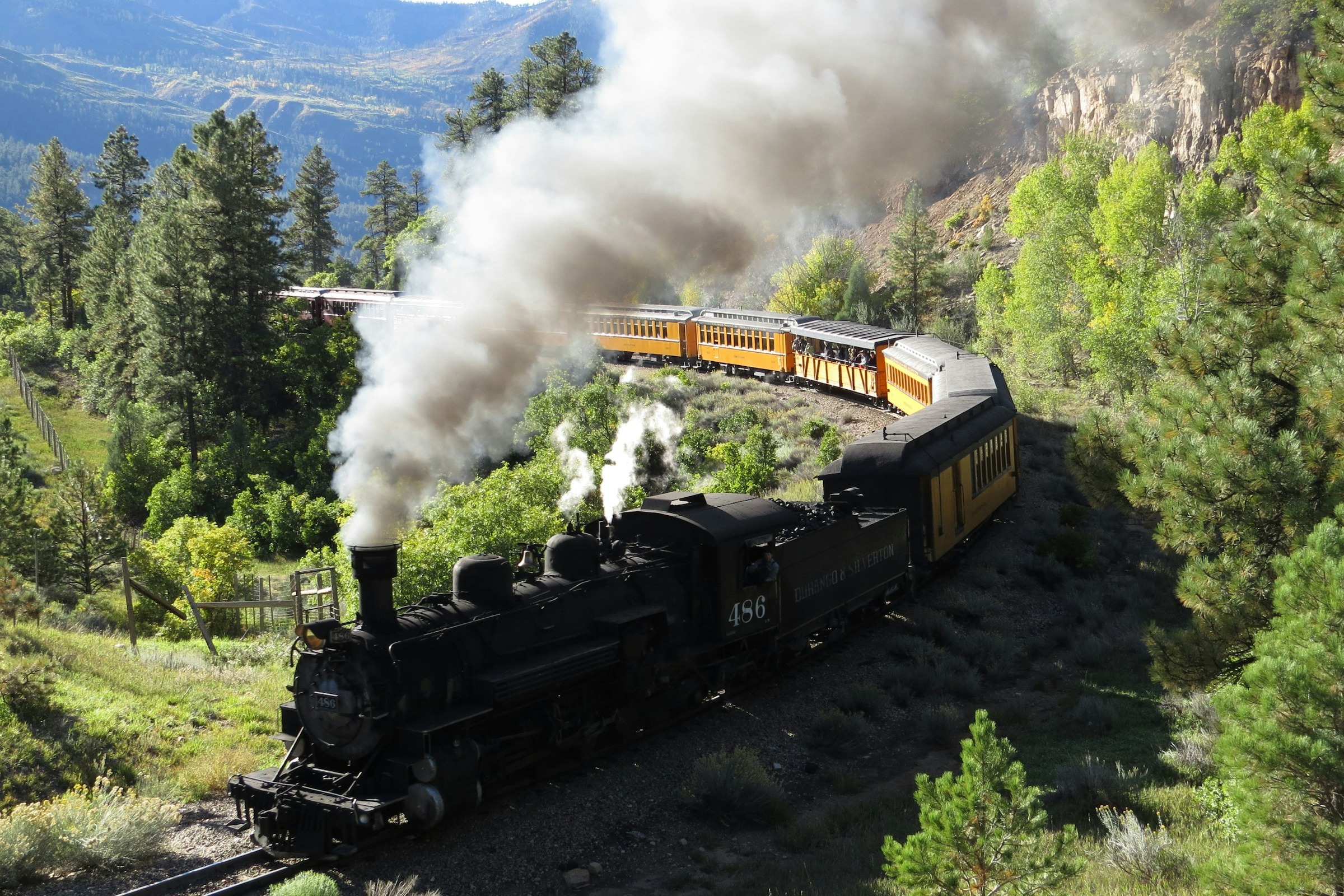 A steam train going through a mountain