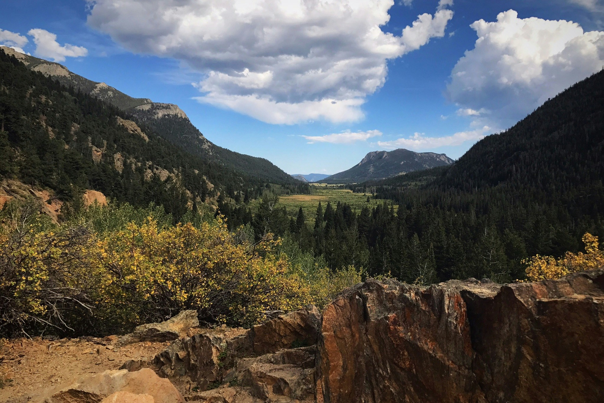 Rocky Mountain National Park's green mountain range under a clear sky.