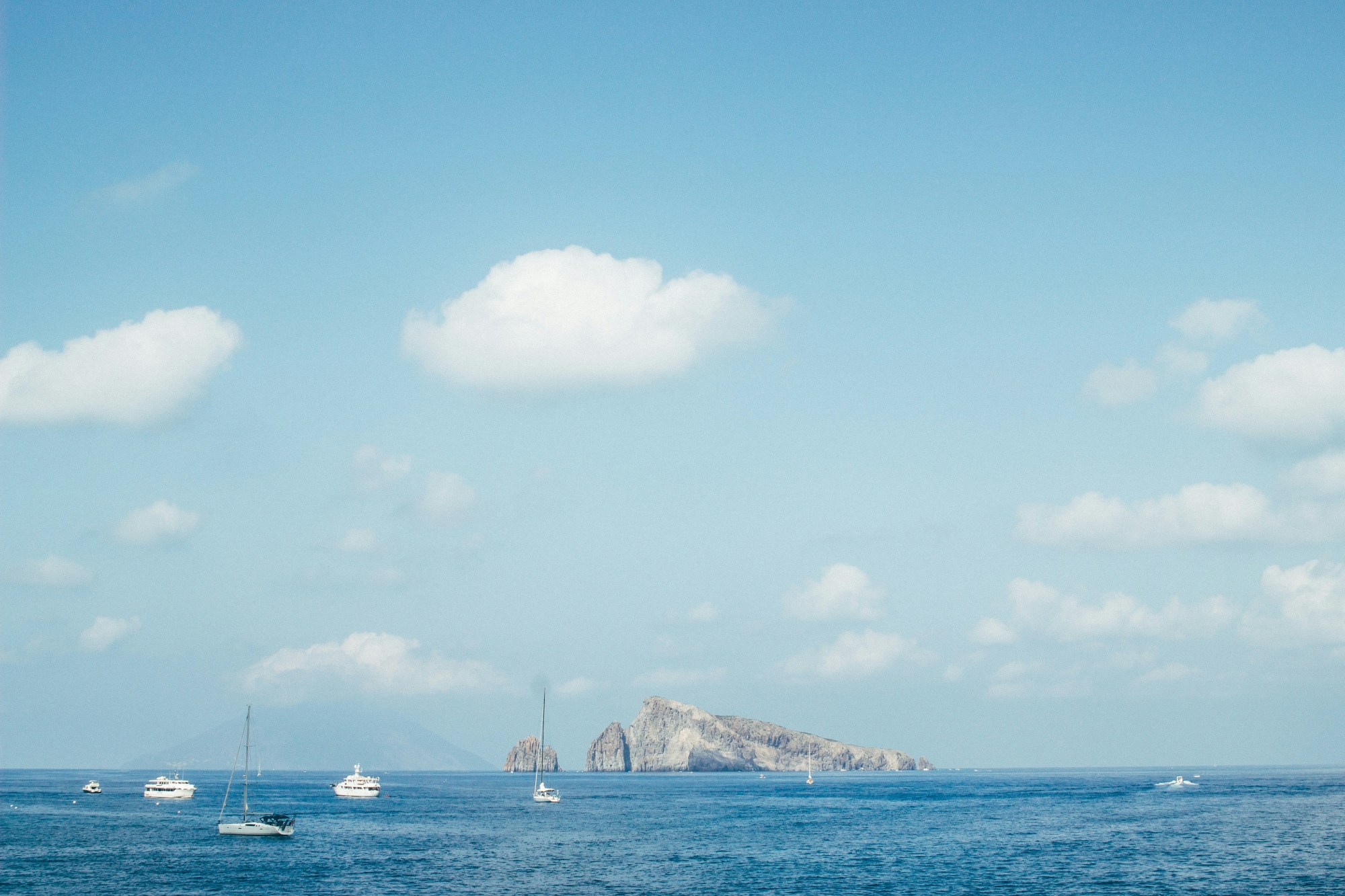 Boats on body of water near island