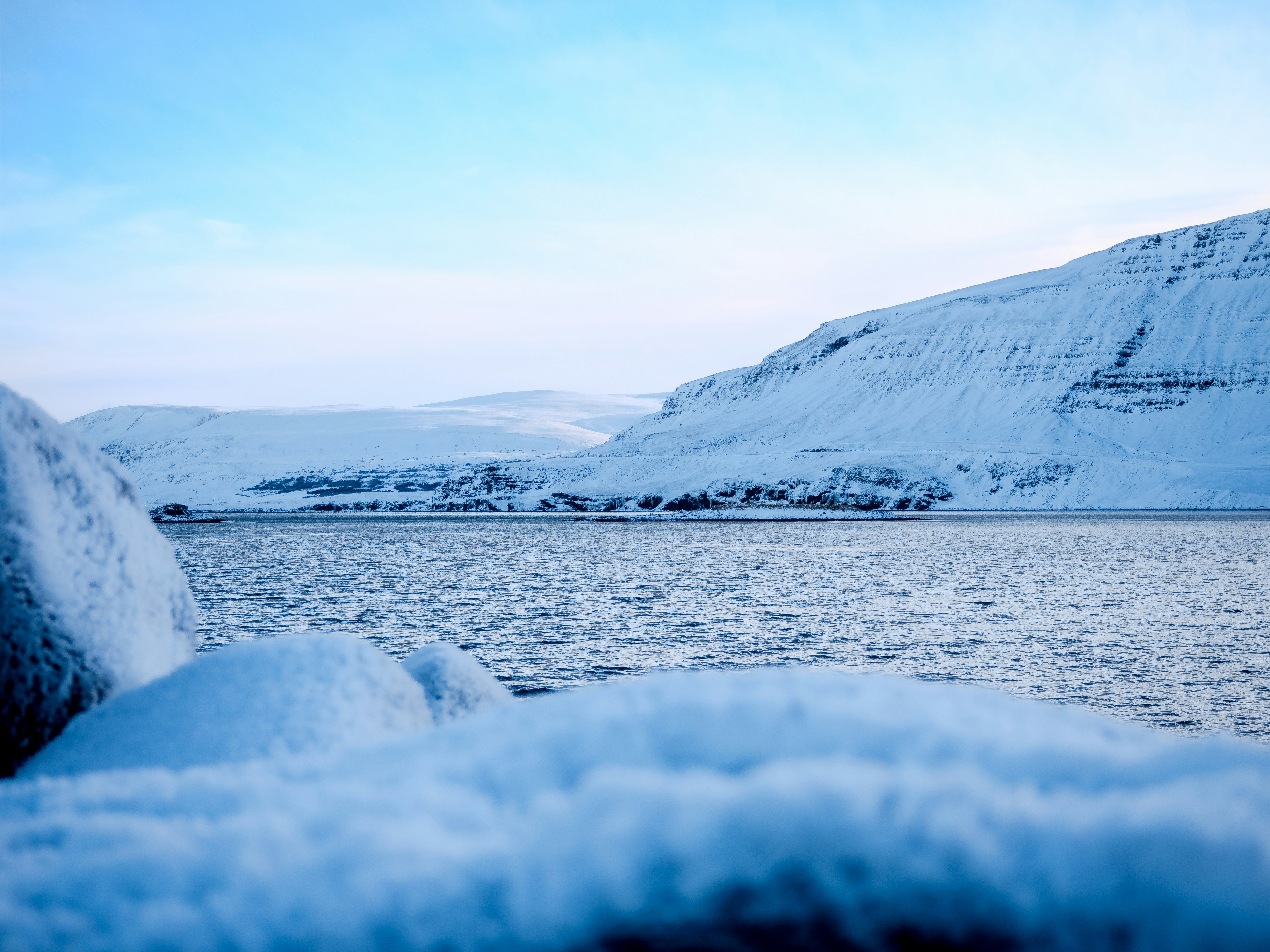 A picture of a body of water surrounded by glaciers taken at daytime.