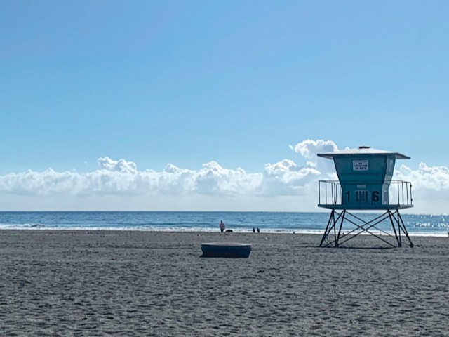 a lifeguard tower on a beach with a boat in the water
