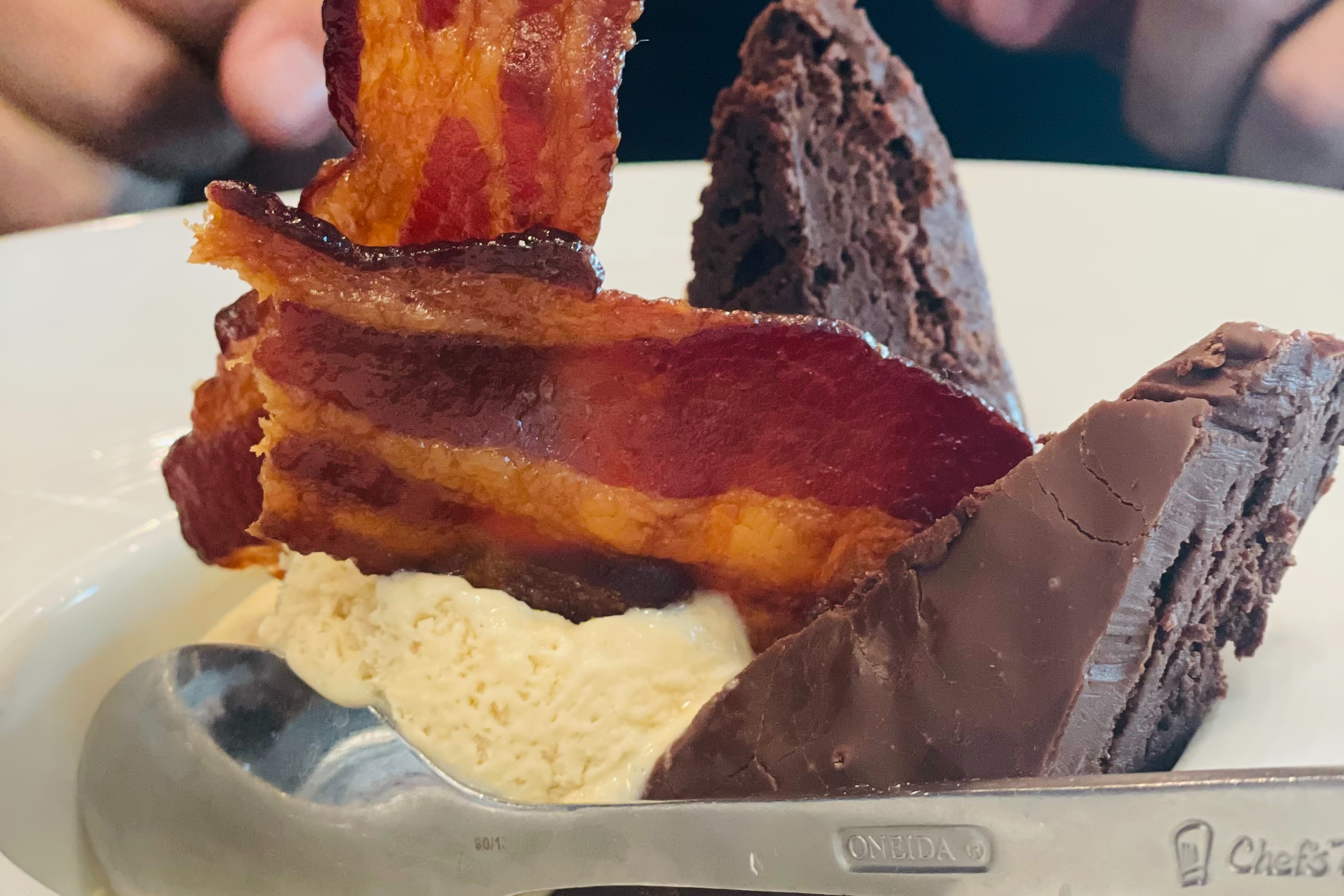 A delicious chocolate cake with ice cream and bacon.