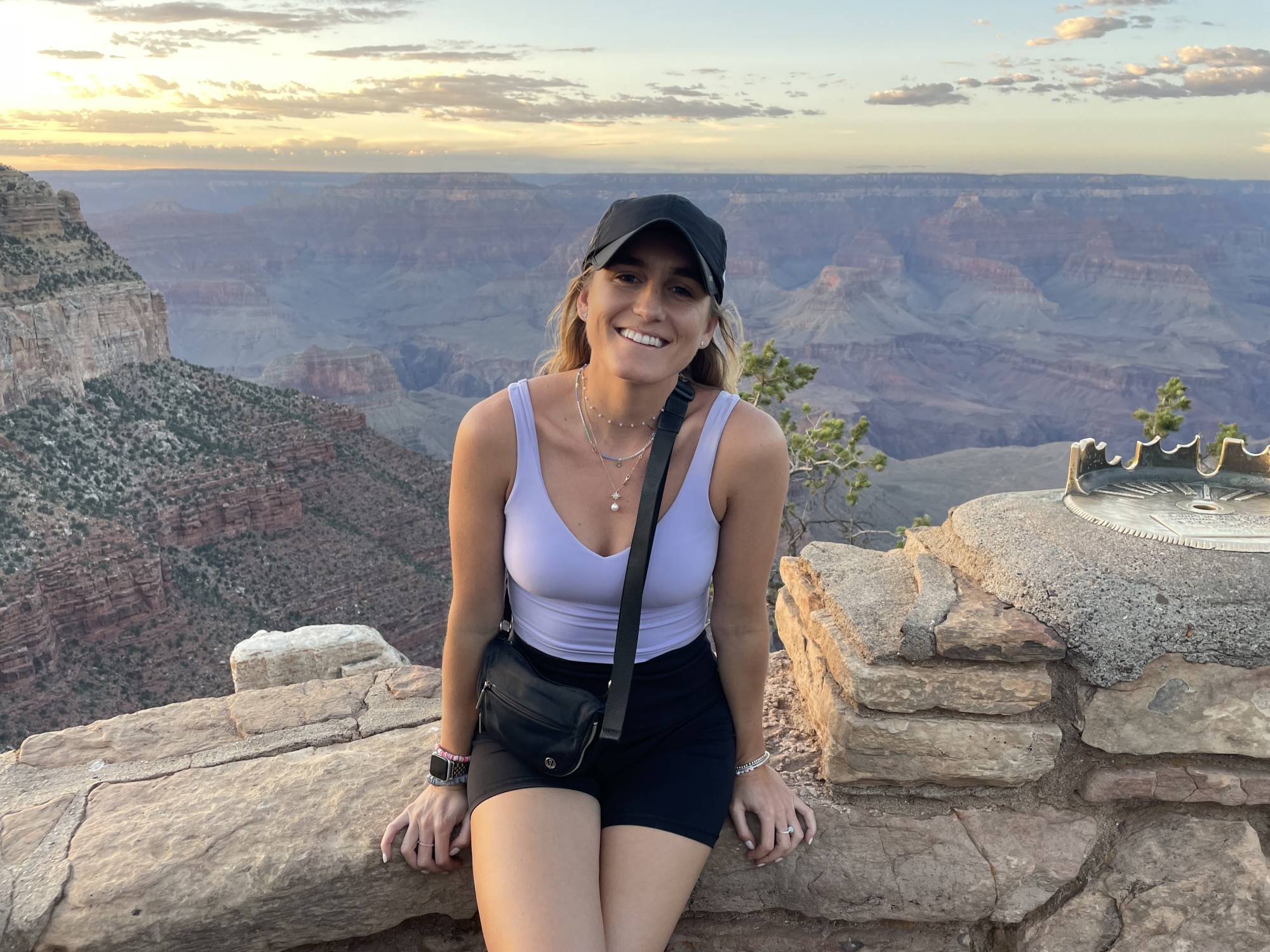 Woman on a hike sitting with canyon views at back.