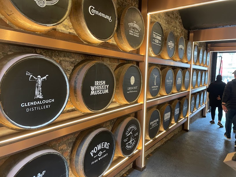 A wall with barrels of different Irish whiskeys.