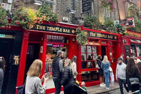 A photo of a red bar with a sign reading "The Temple Bar"