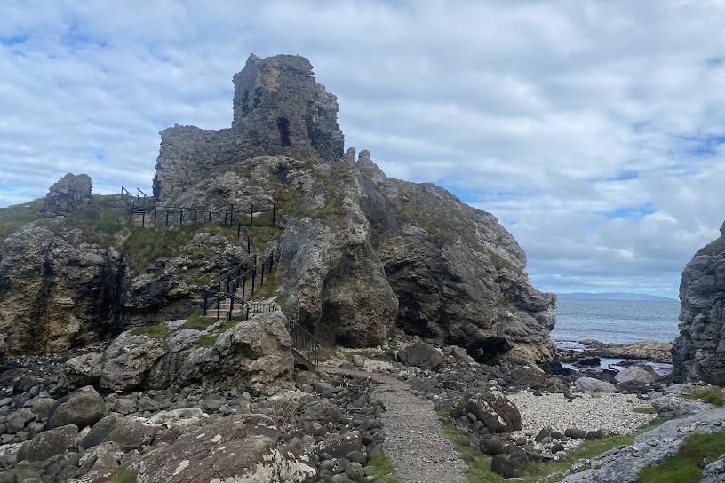 Castle ruins at the top of a rocky cliff during daytime