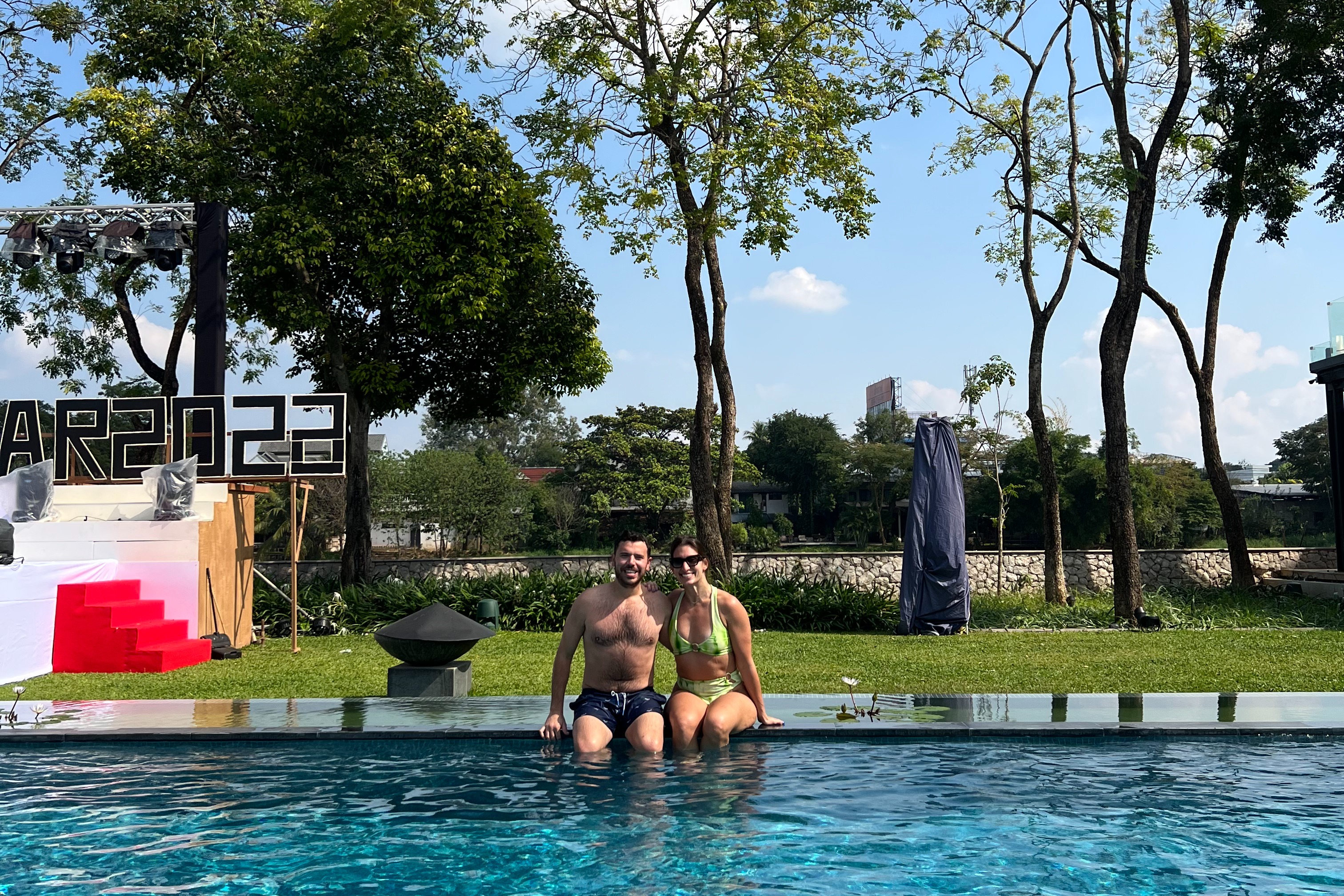 A couple posing for a photo in a swimming pool during the daytime