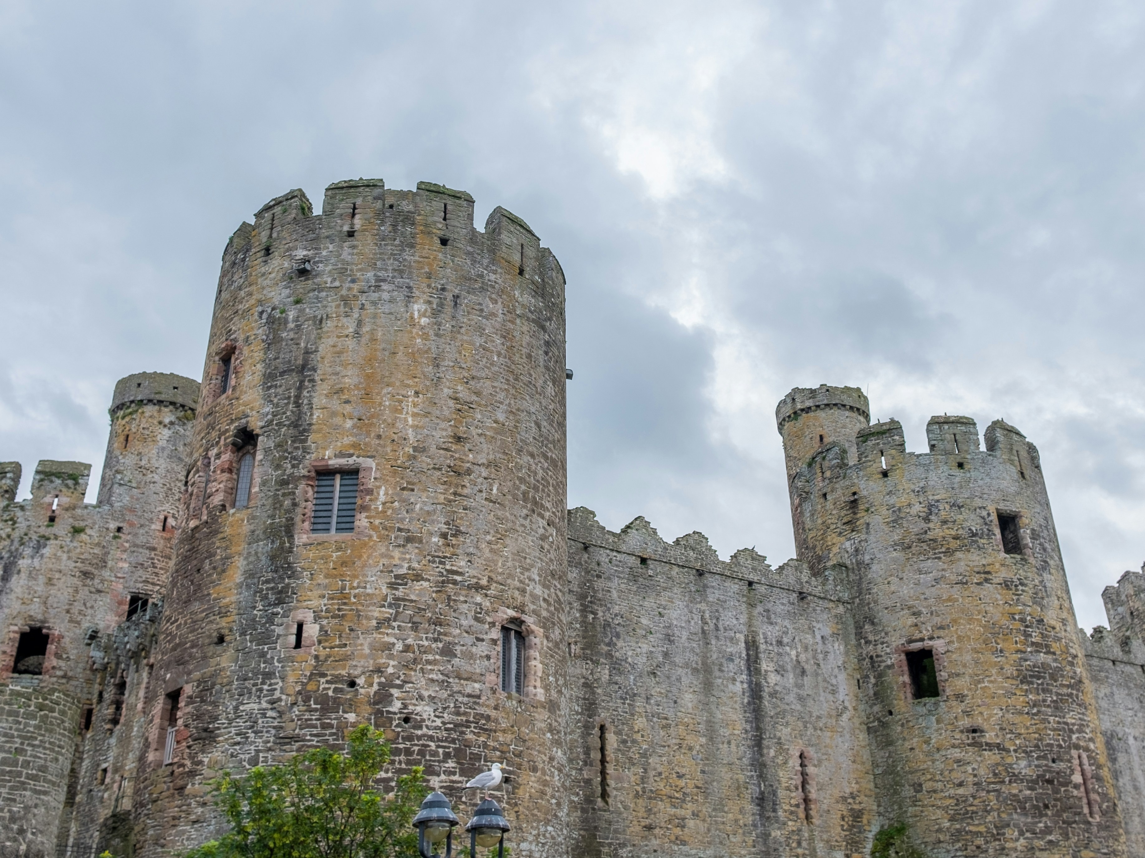 A picture of an old stone castle with a cloudy sky in the background.