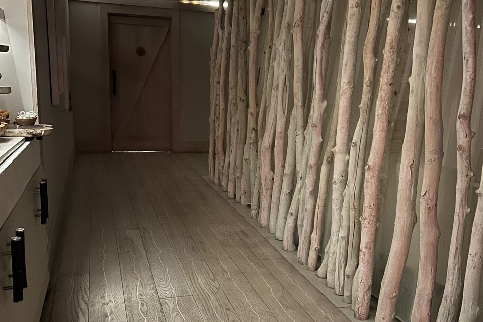 An indoor hallway with tree branches decorating the wall