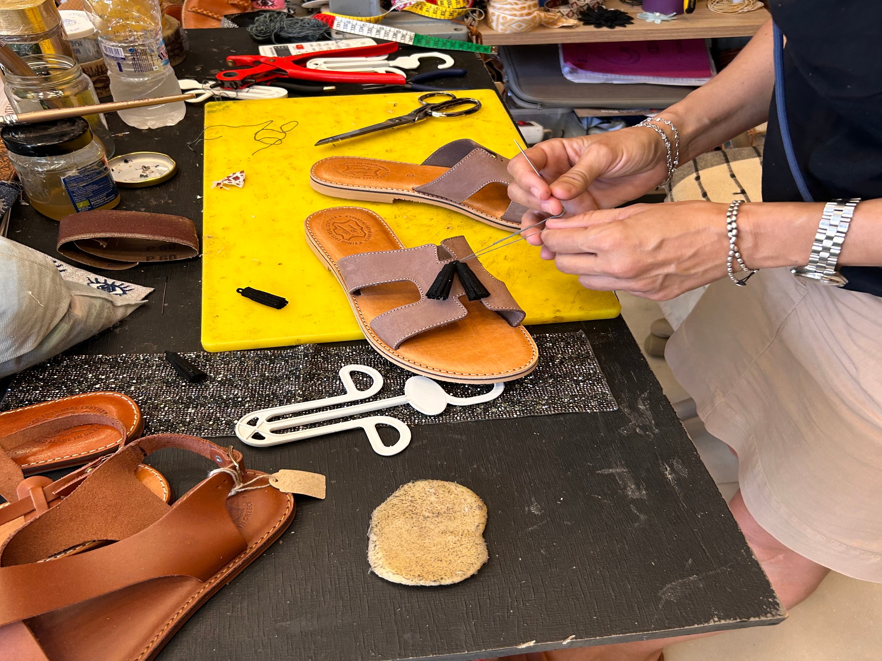 A picture of a person making Sandals at a store