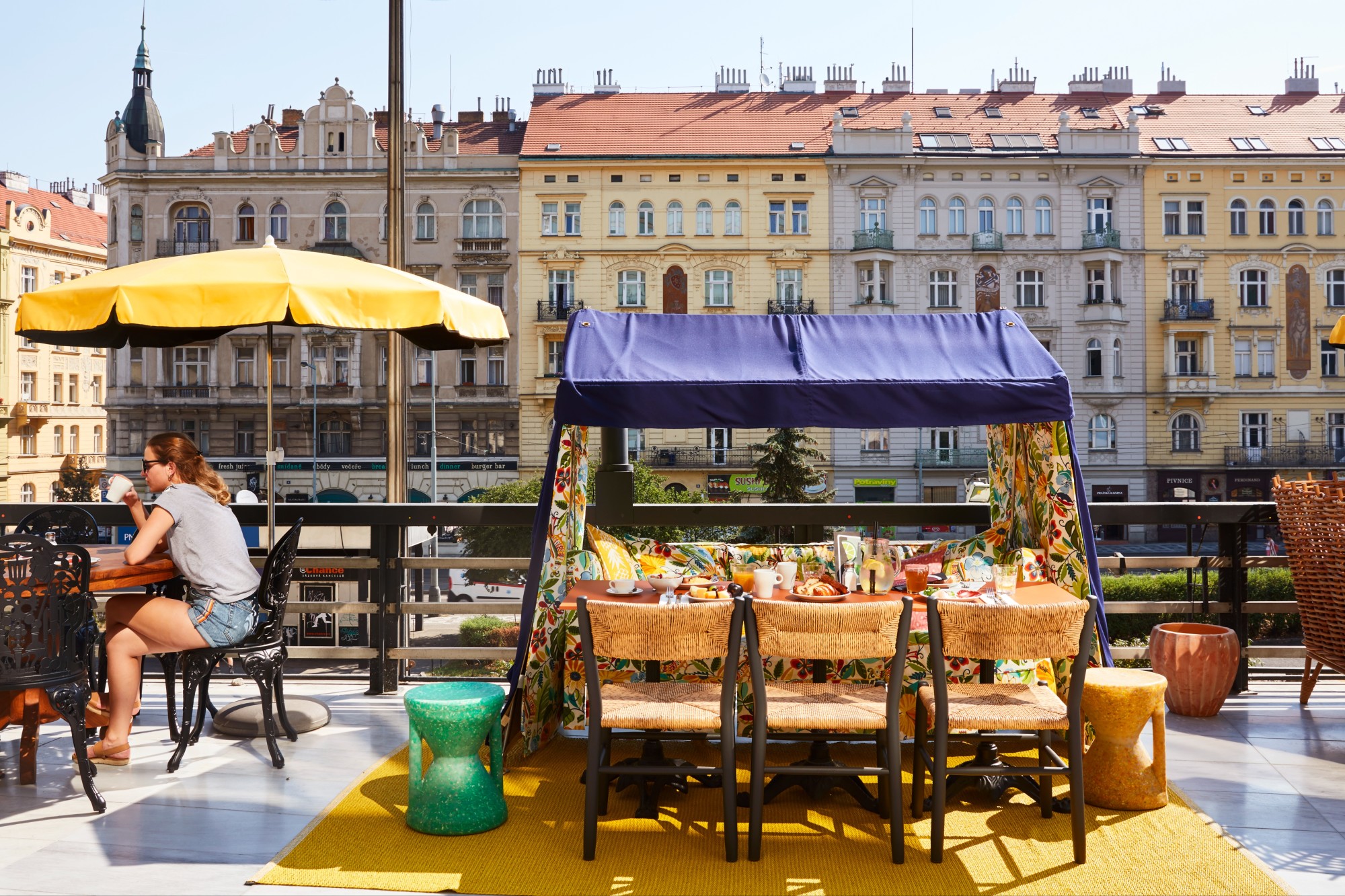 a tented fruit cart on a sunny outdoor urban terrace