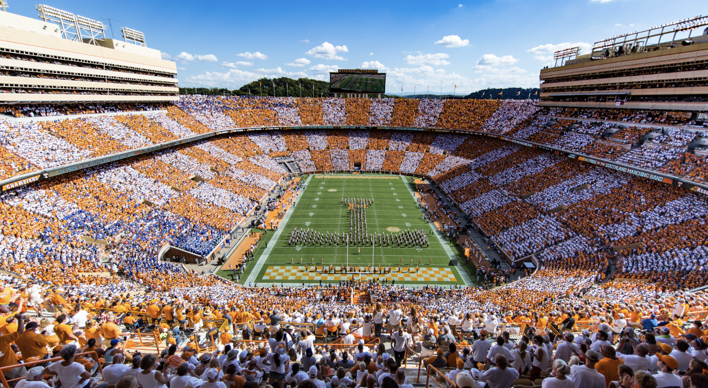 A large football field and stadium with a full crowd of people in the stands