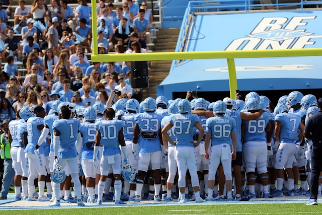 A football team on the field wearing blue jerseys