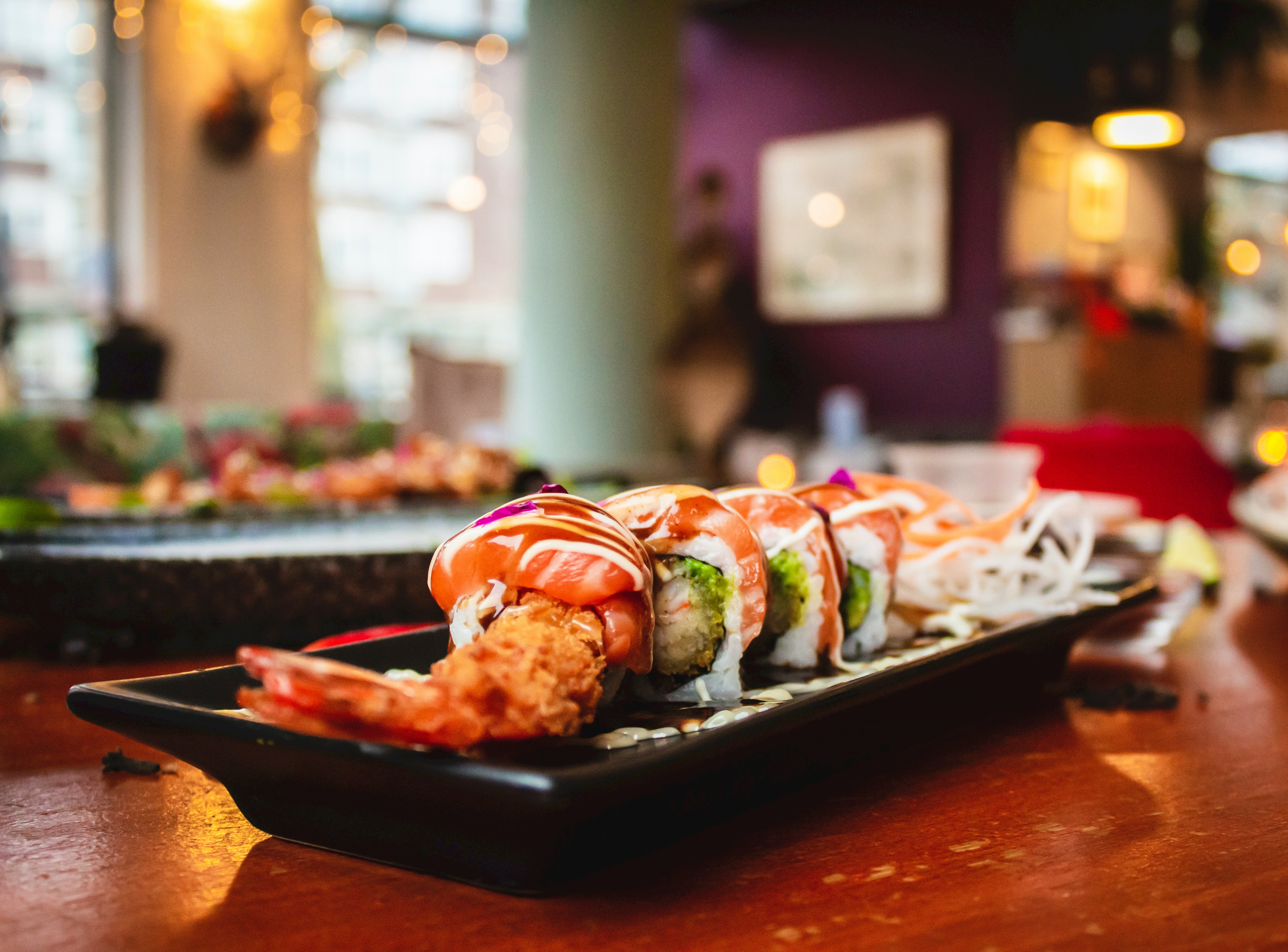 A picture of sushi served on plater on a restaurant table.