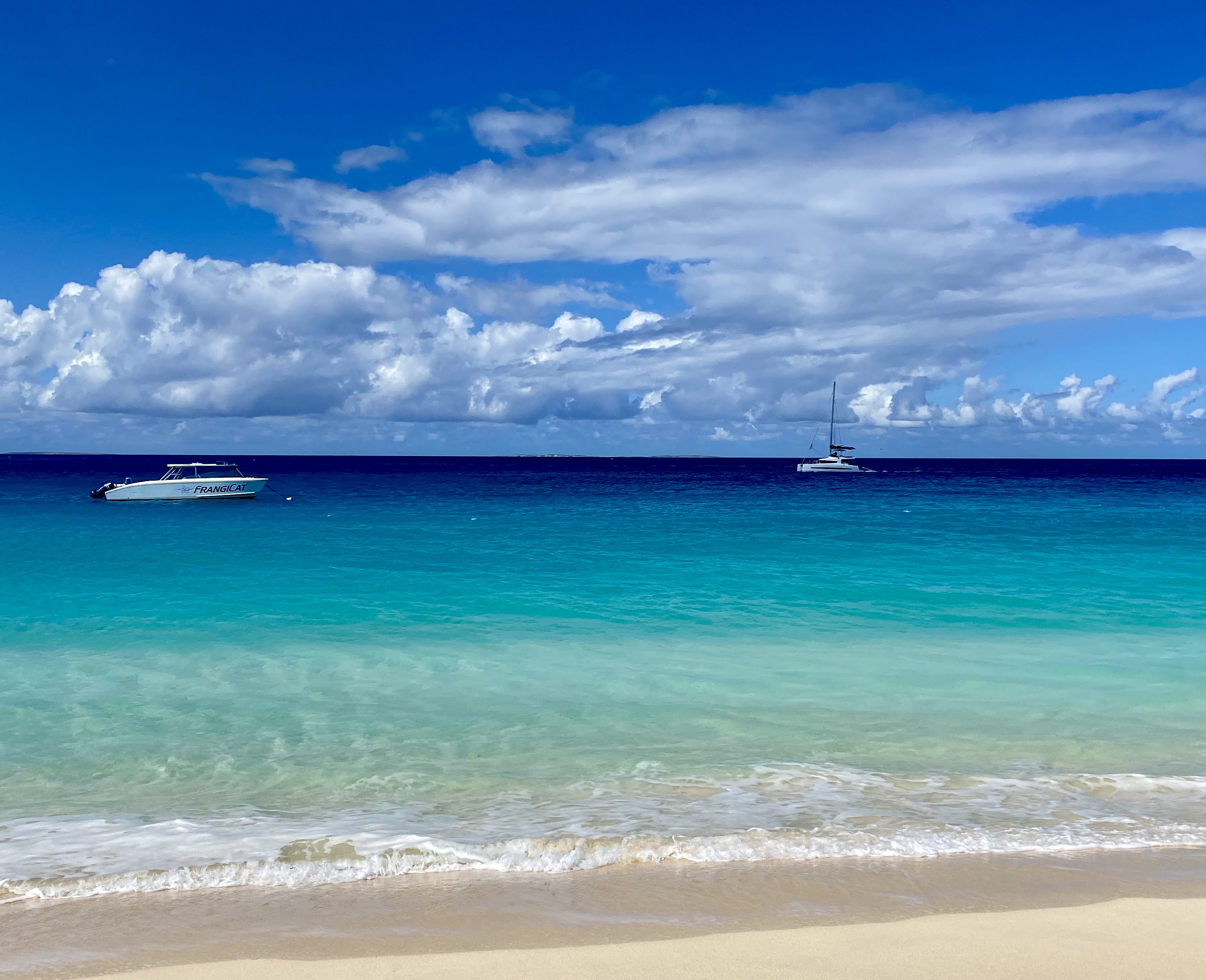 beach and sky with clouds and boats