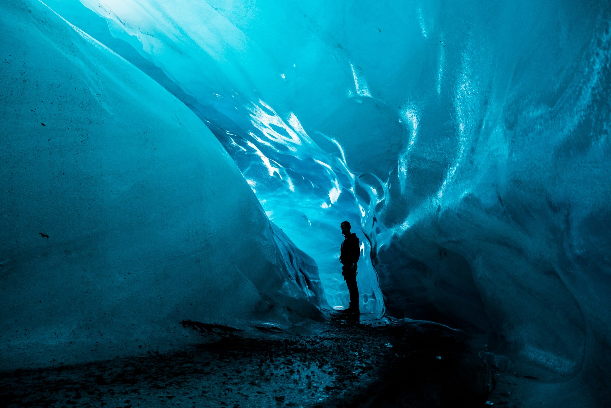 A man standing in an ice cave.