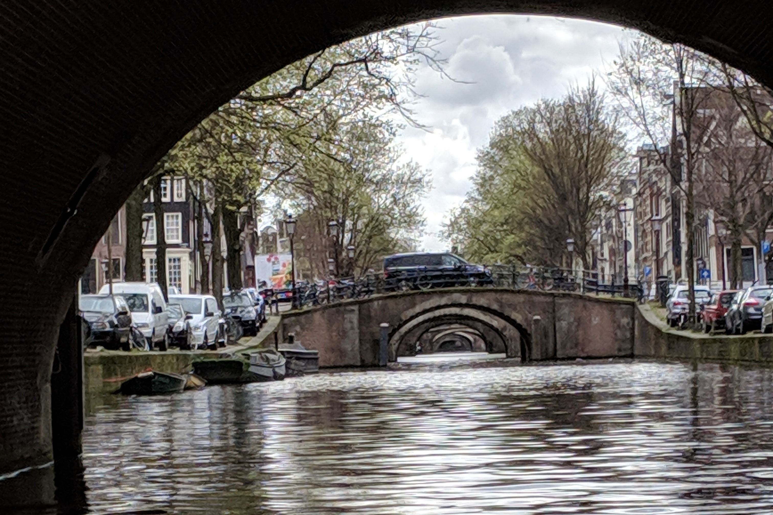 A view from underneath a bridge of a canal and other bridges in Amsterdam