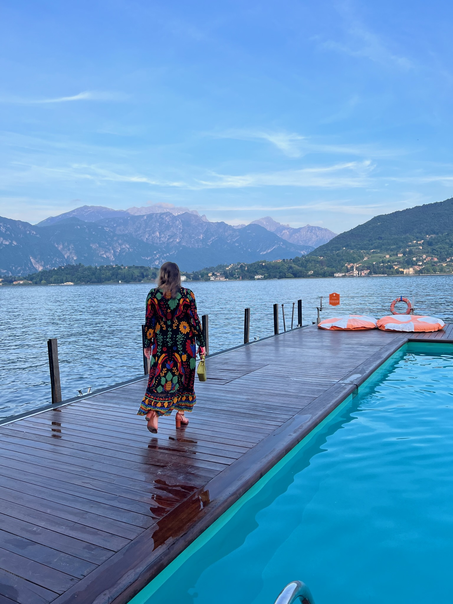 Picture of Gianna walking along the pool with beautiful lake view