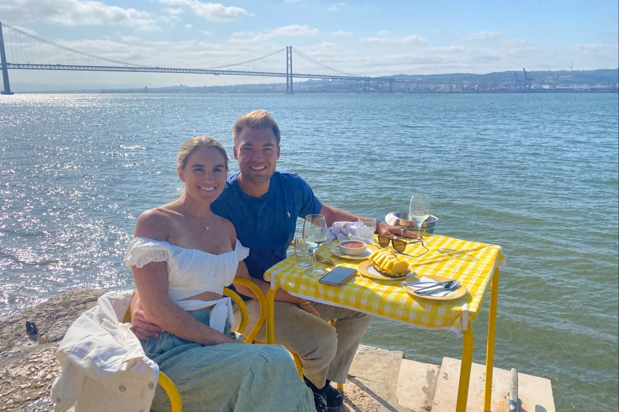 A picture of a couple having breakfast near the water.