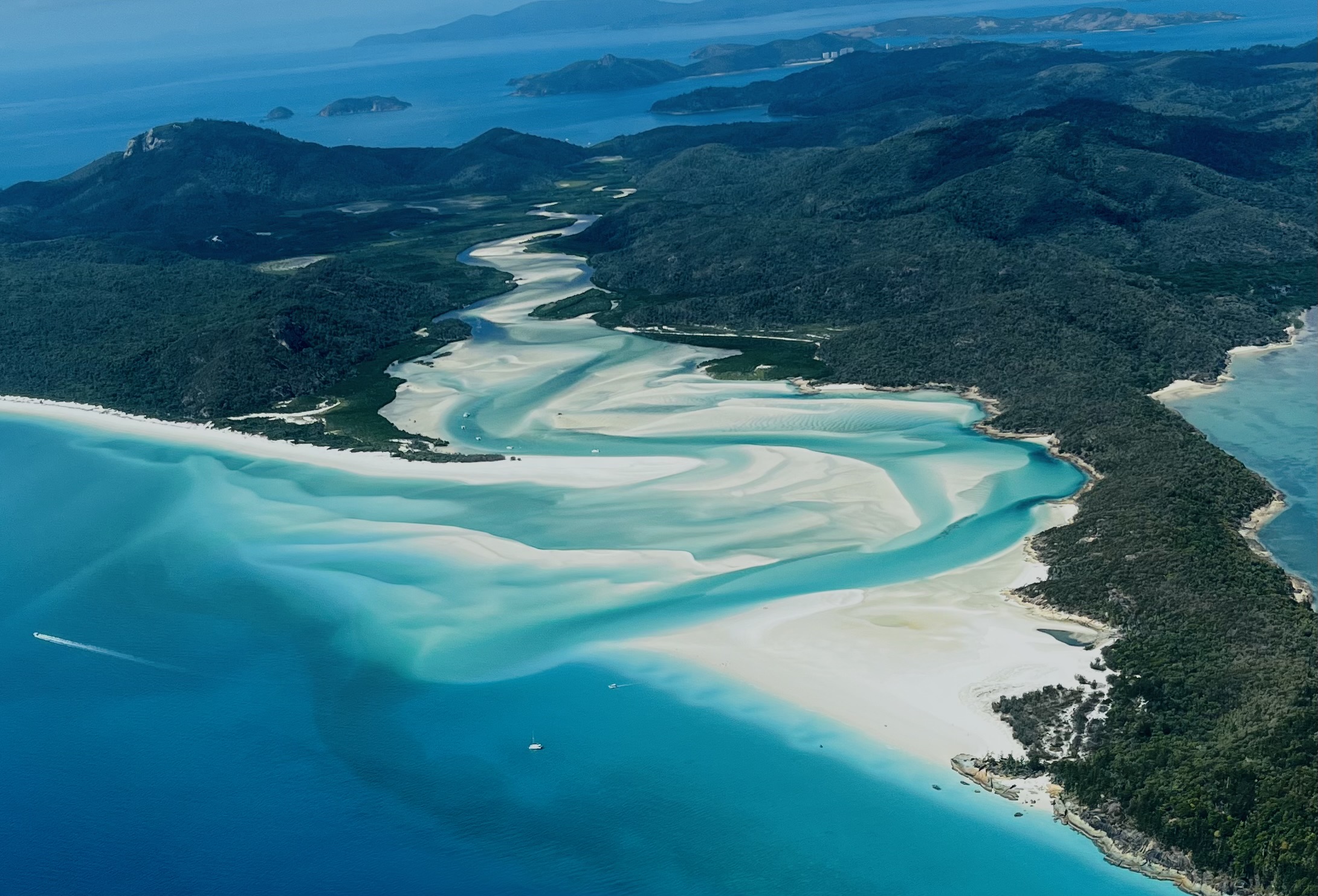 Areal view of an Island with lush greenery and blue waters