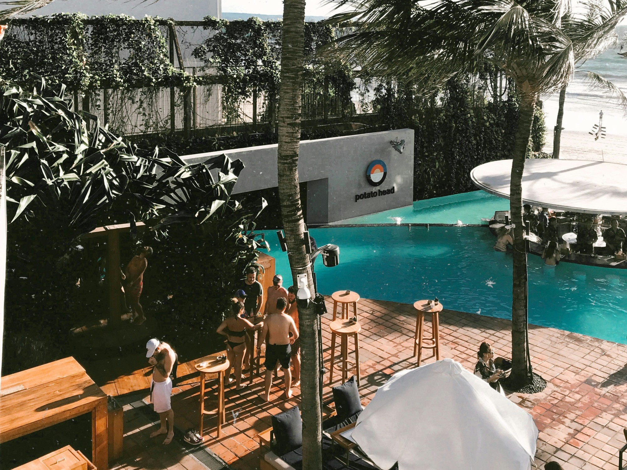A beach club with people and pool.