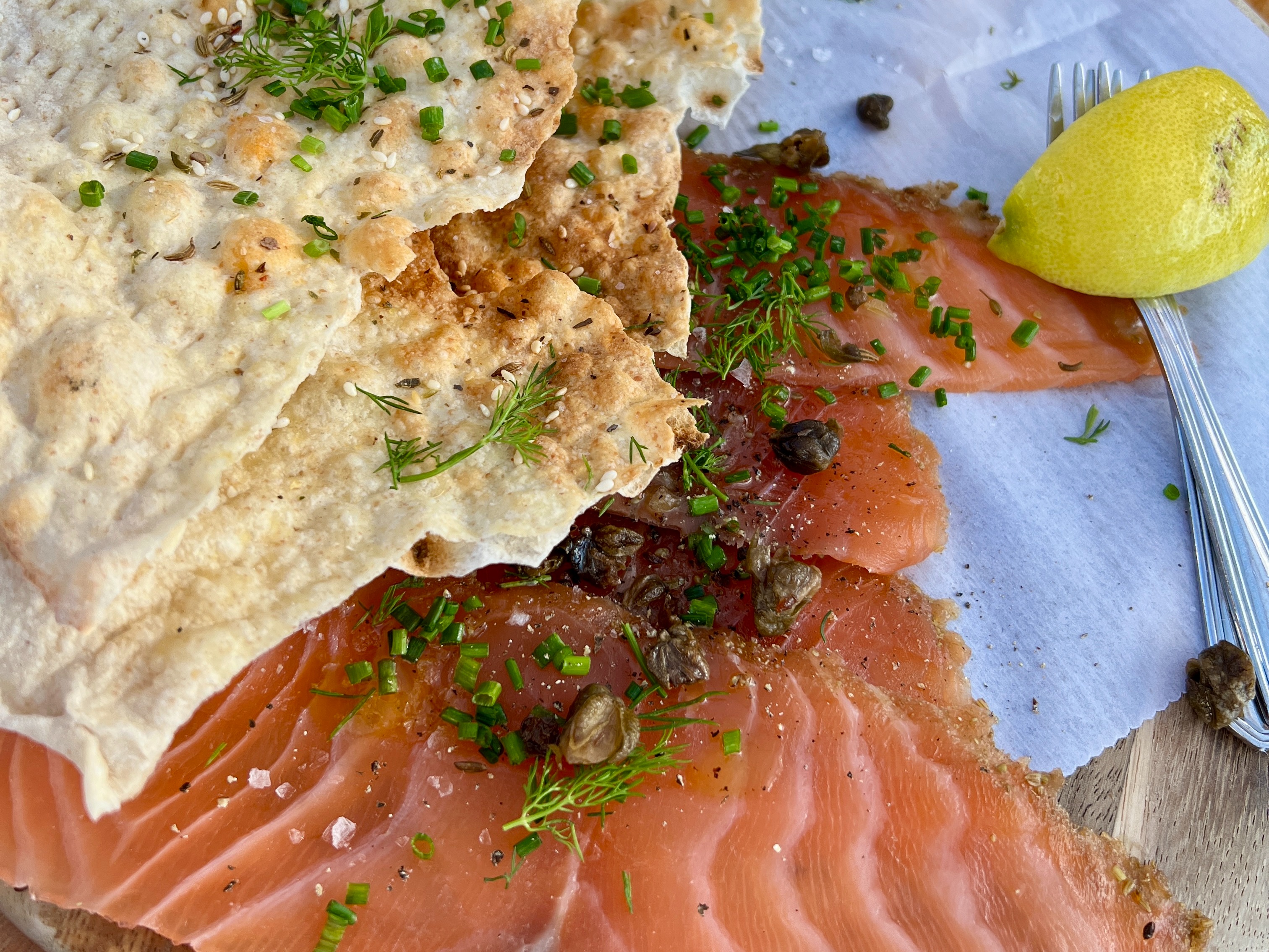 Little Doms Seafood Cold Smoked Samon with a lemon slice and some toasted flat bread.