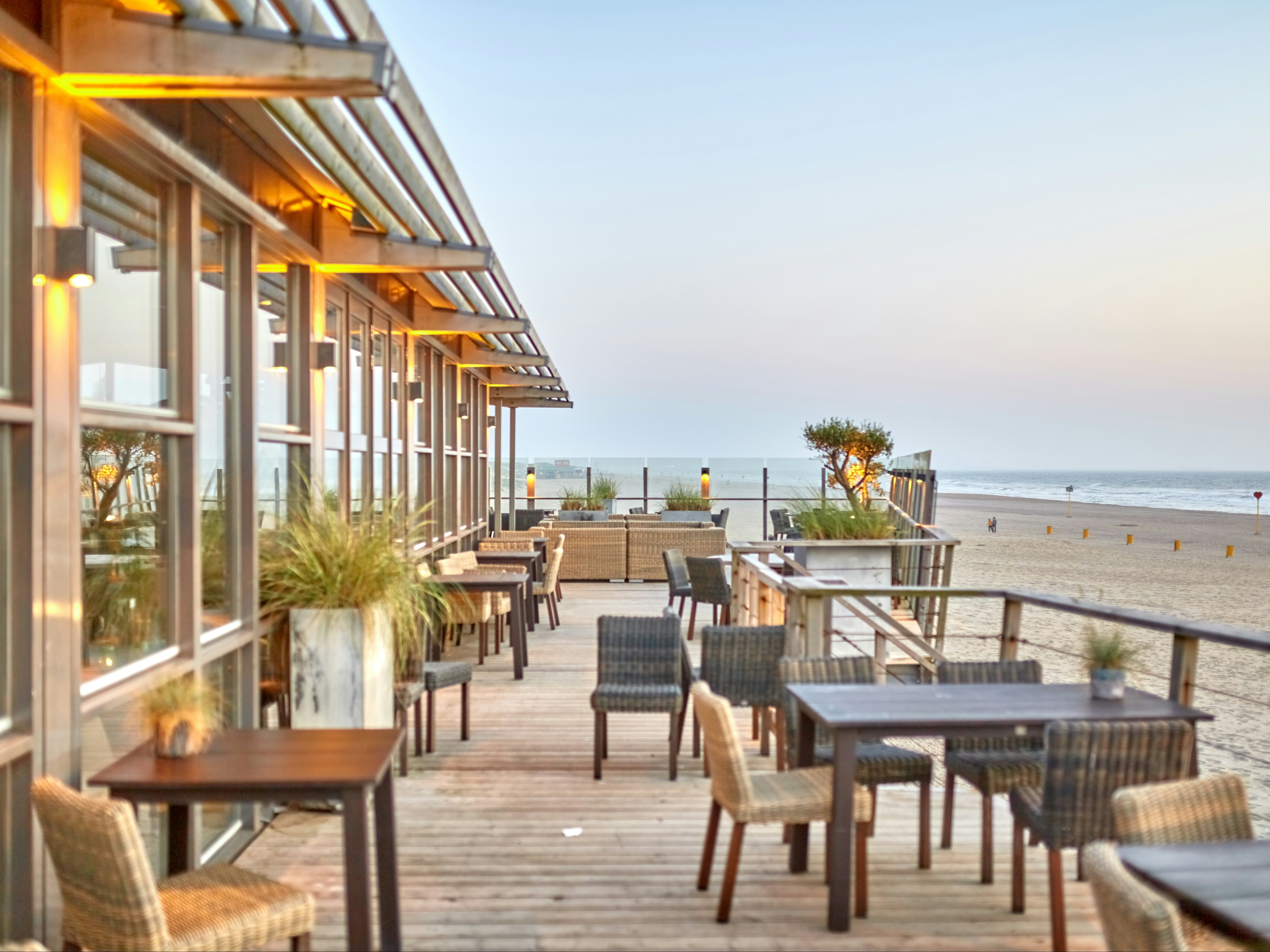 A picture of an outdoor restaurant on the beach during the daytime.