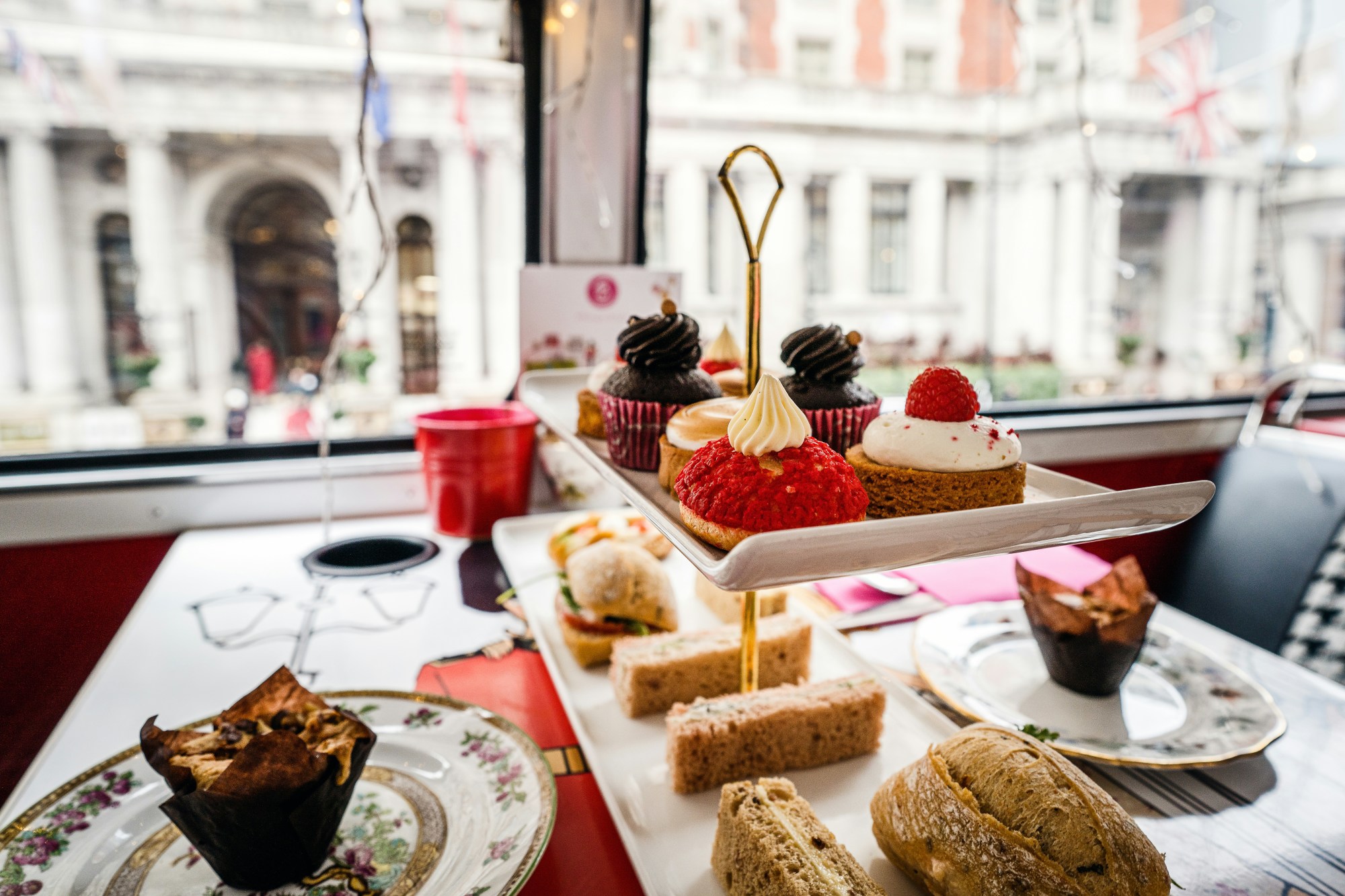 A platter of pastries on a table in a restaurant near window.