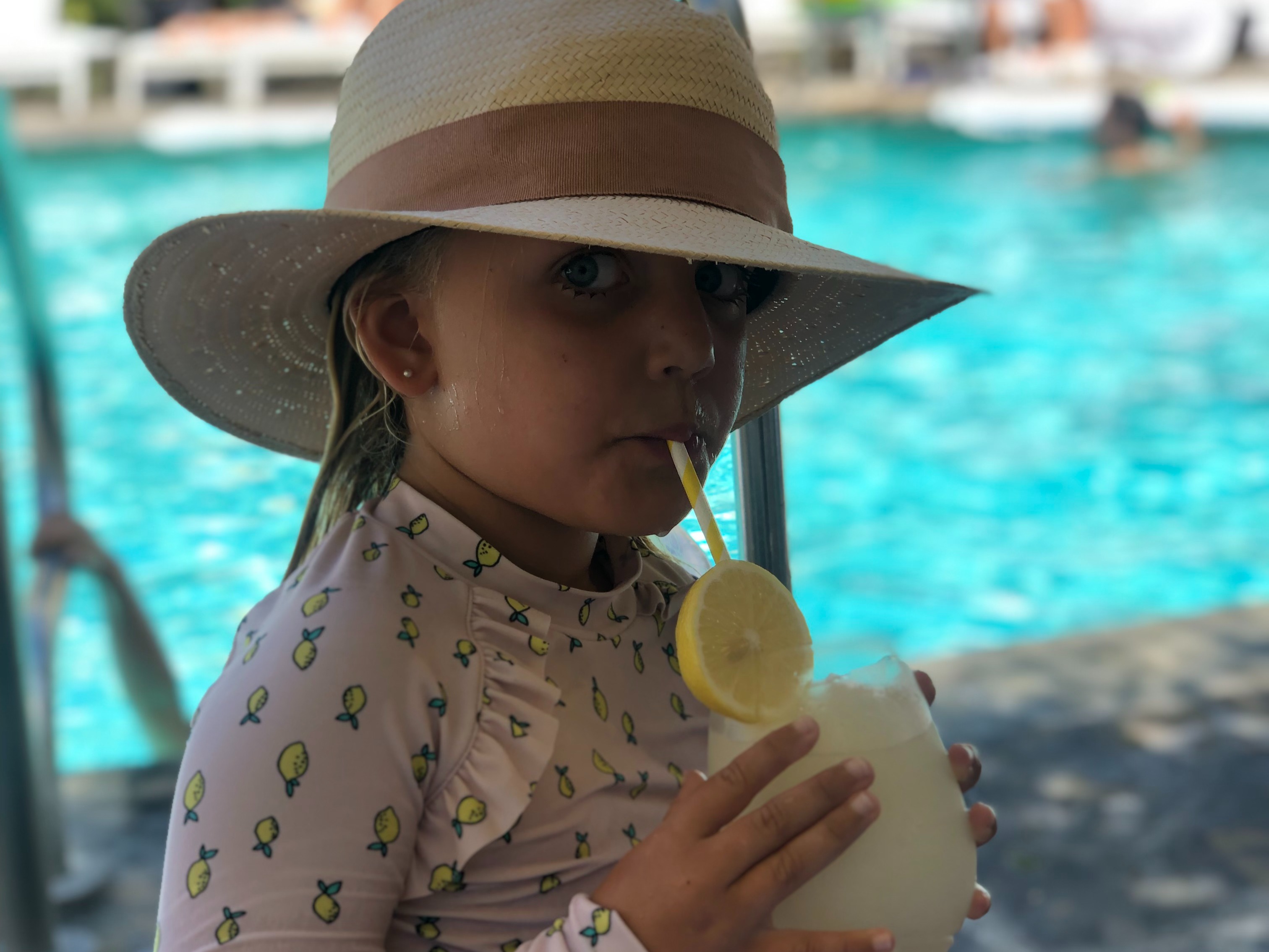 Kid having a juice in a parker's pool