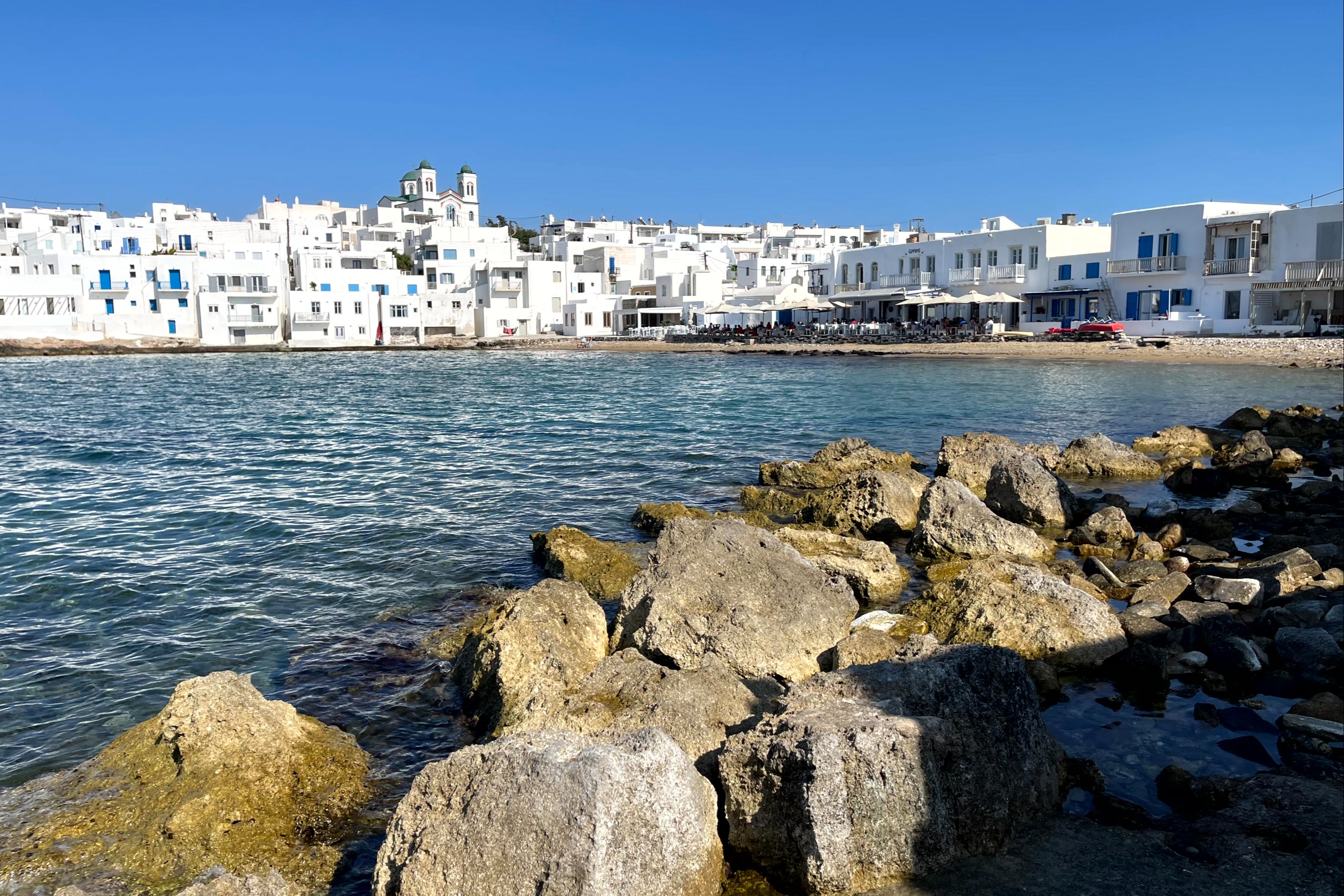 An aerial view of the white colored houses on the shore of the sea.