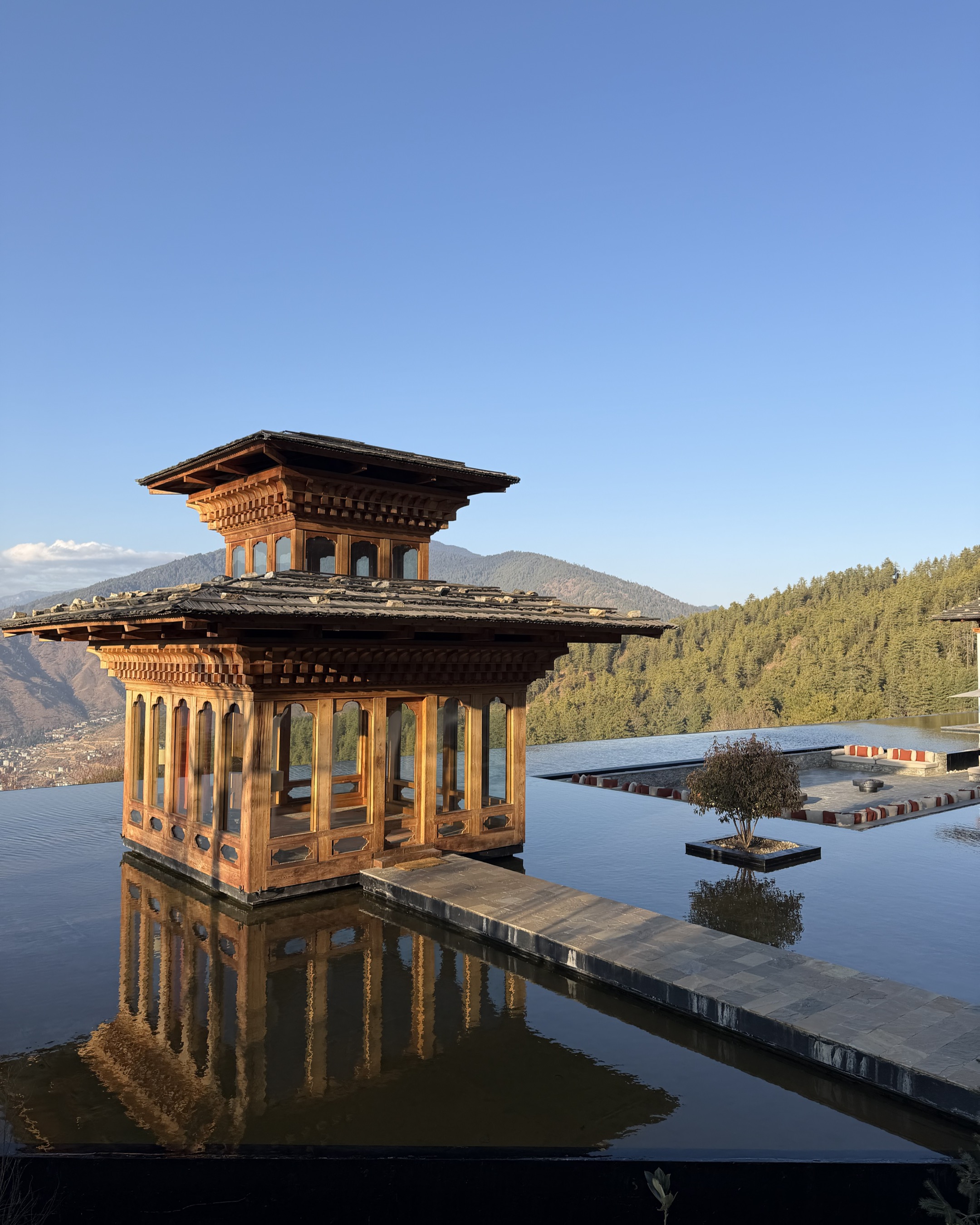 Six Senses Thimphu main building with reflecting pool and valley views.
