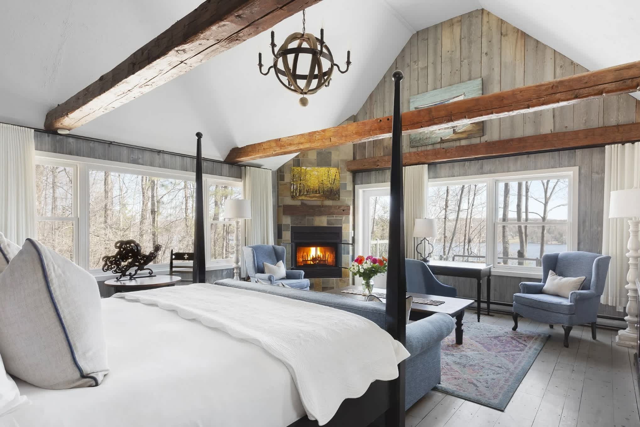 bedroom with vaulted ceilings, wood beams and a fireplace