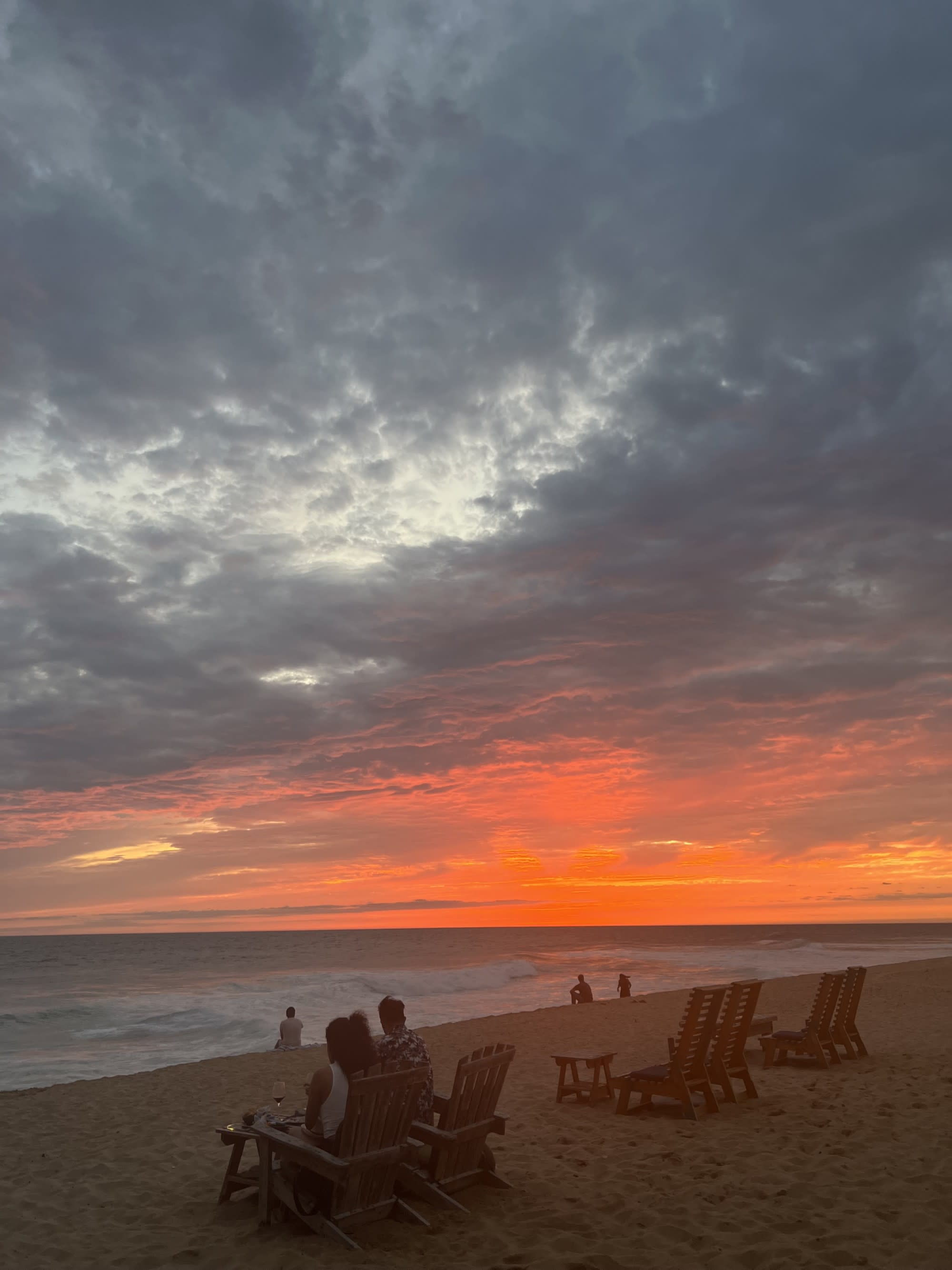 Beach with lounge chairs set up at sunset.