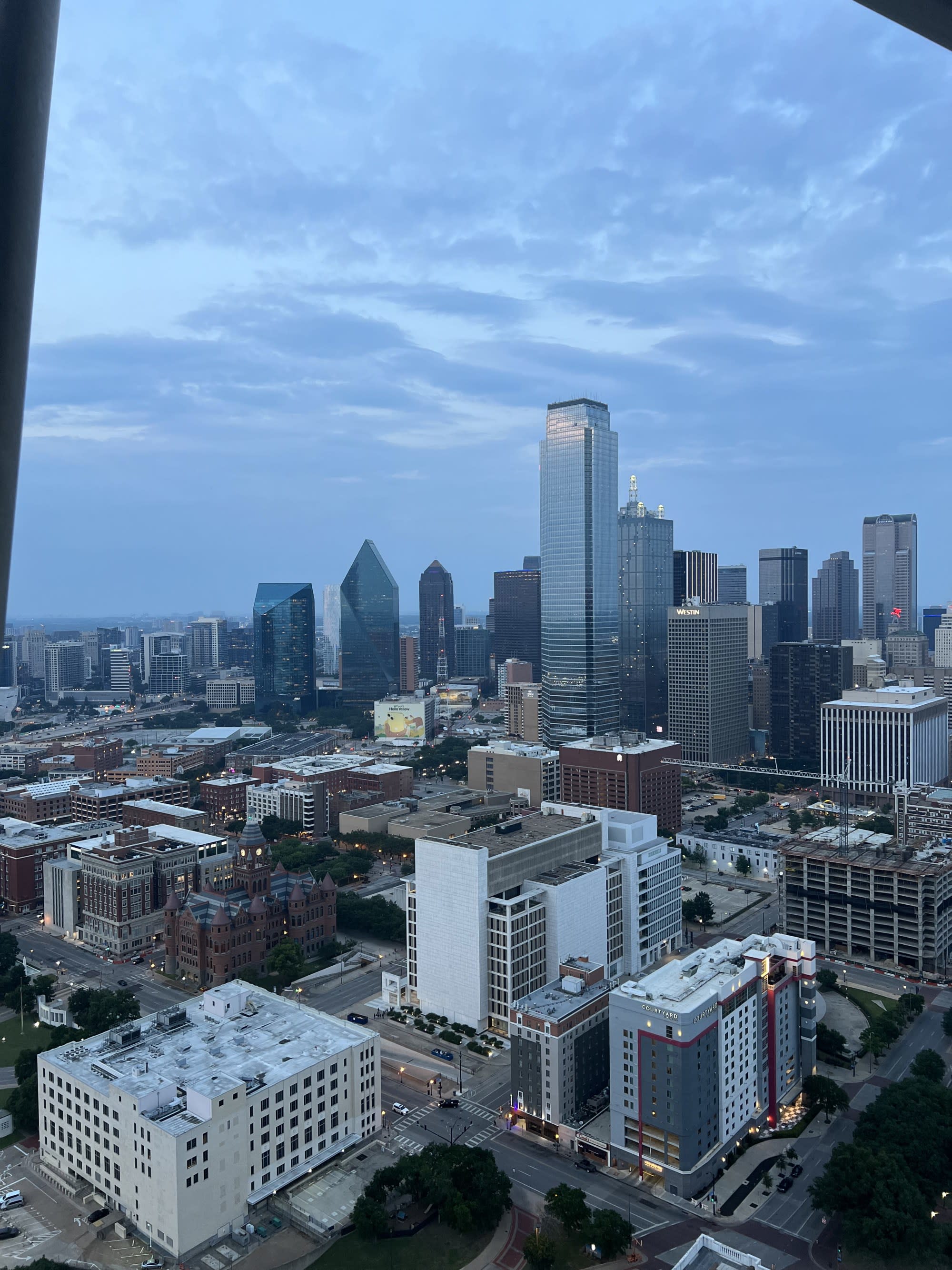City skyline from a window under a cloudy sky.