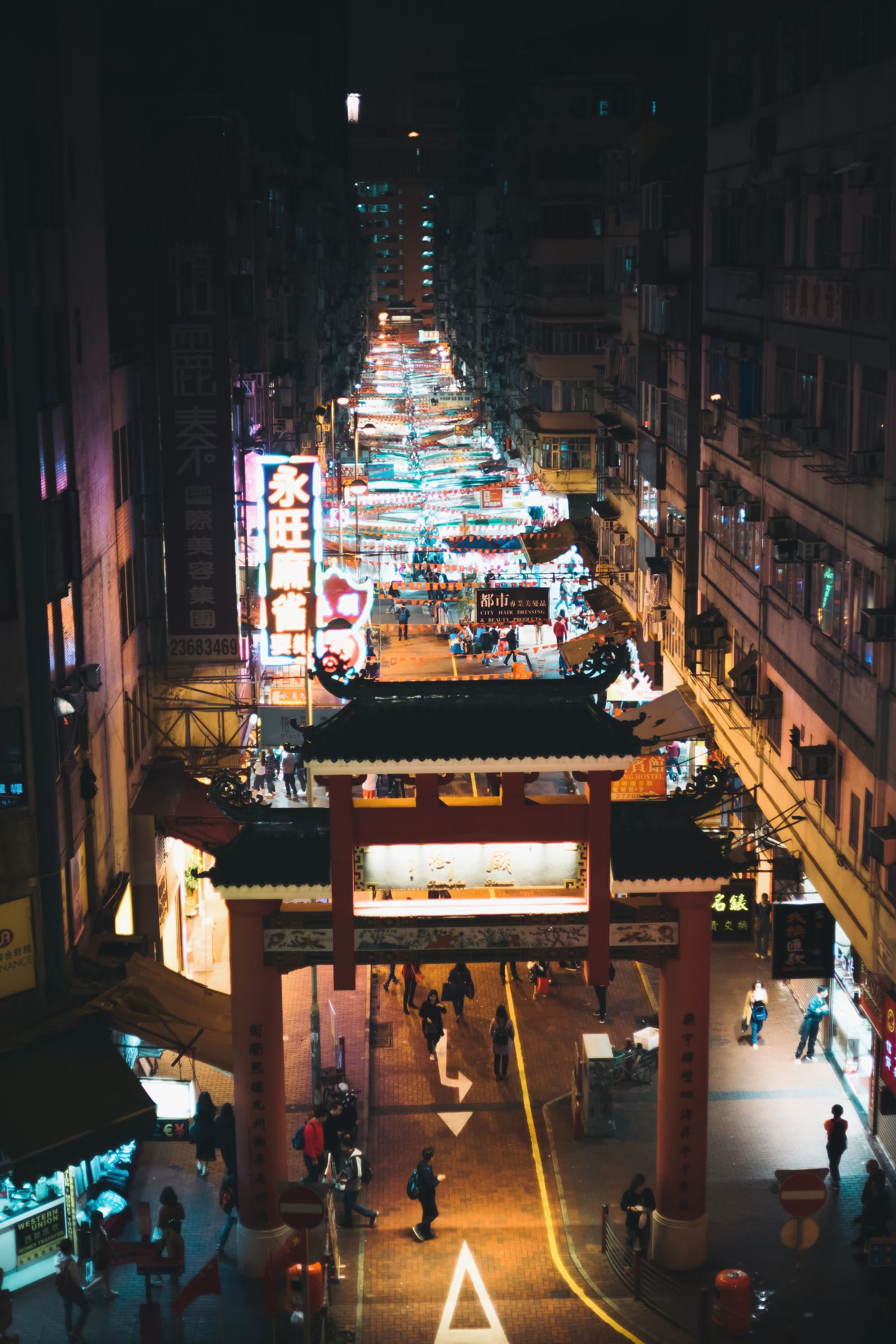 long city street with night market lit up by