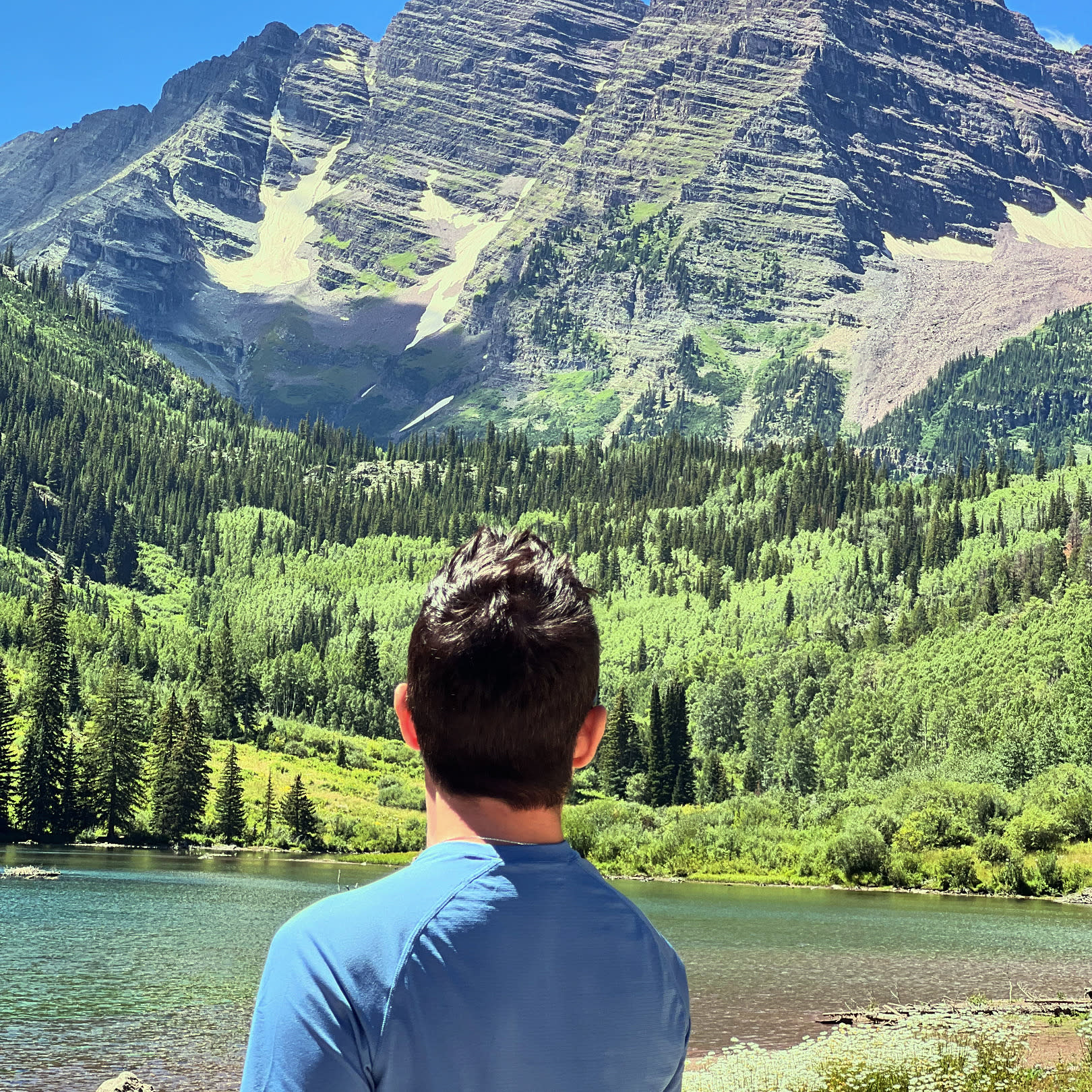 A man looking over a lake and a mountain.