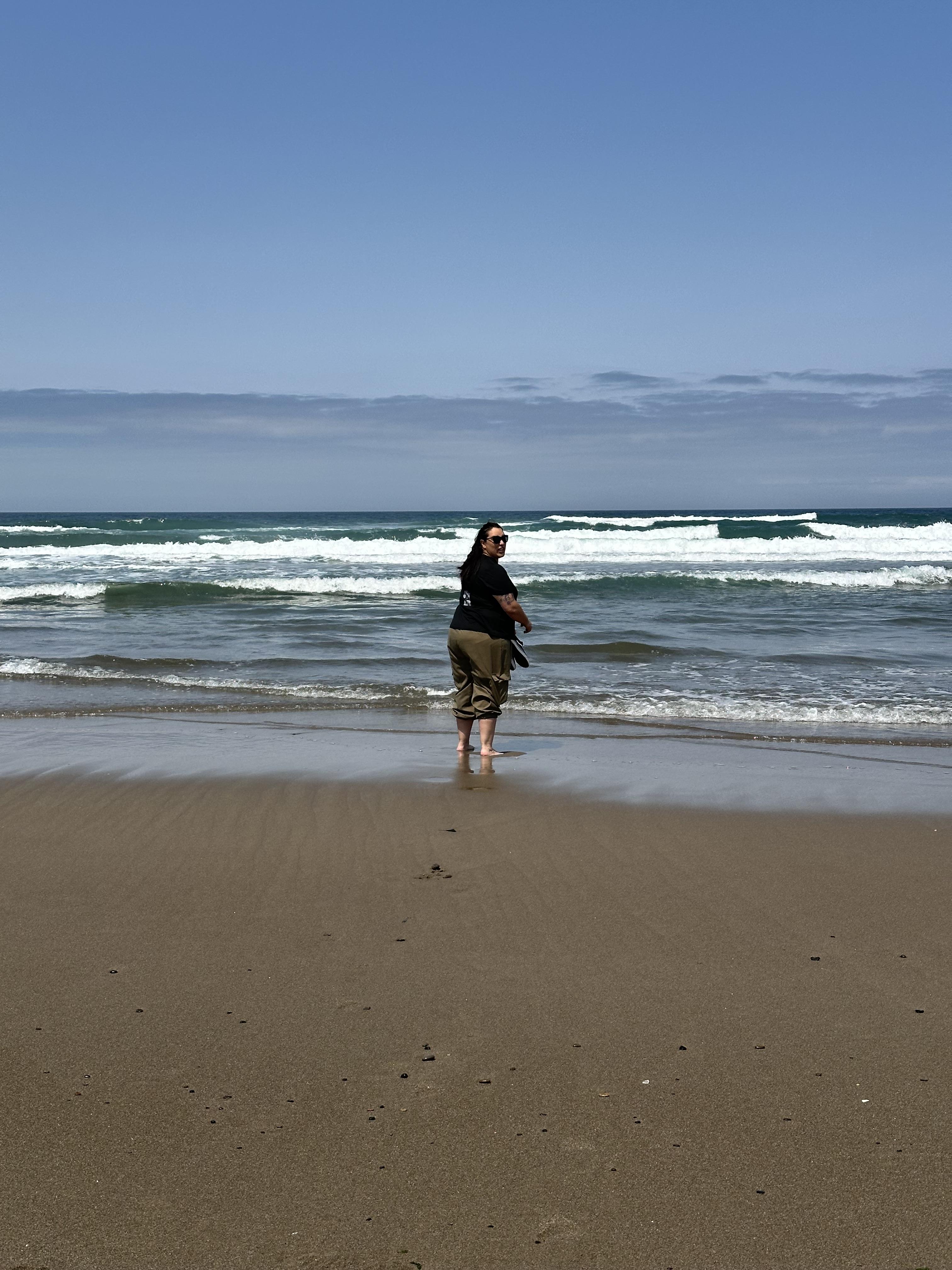 Woman on a beach with small surf.