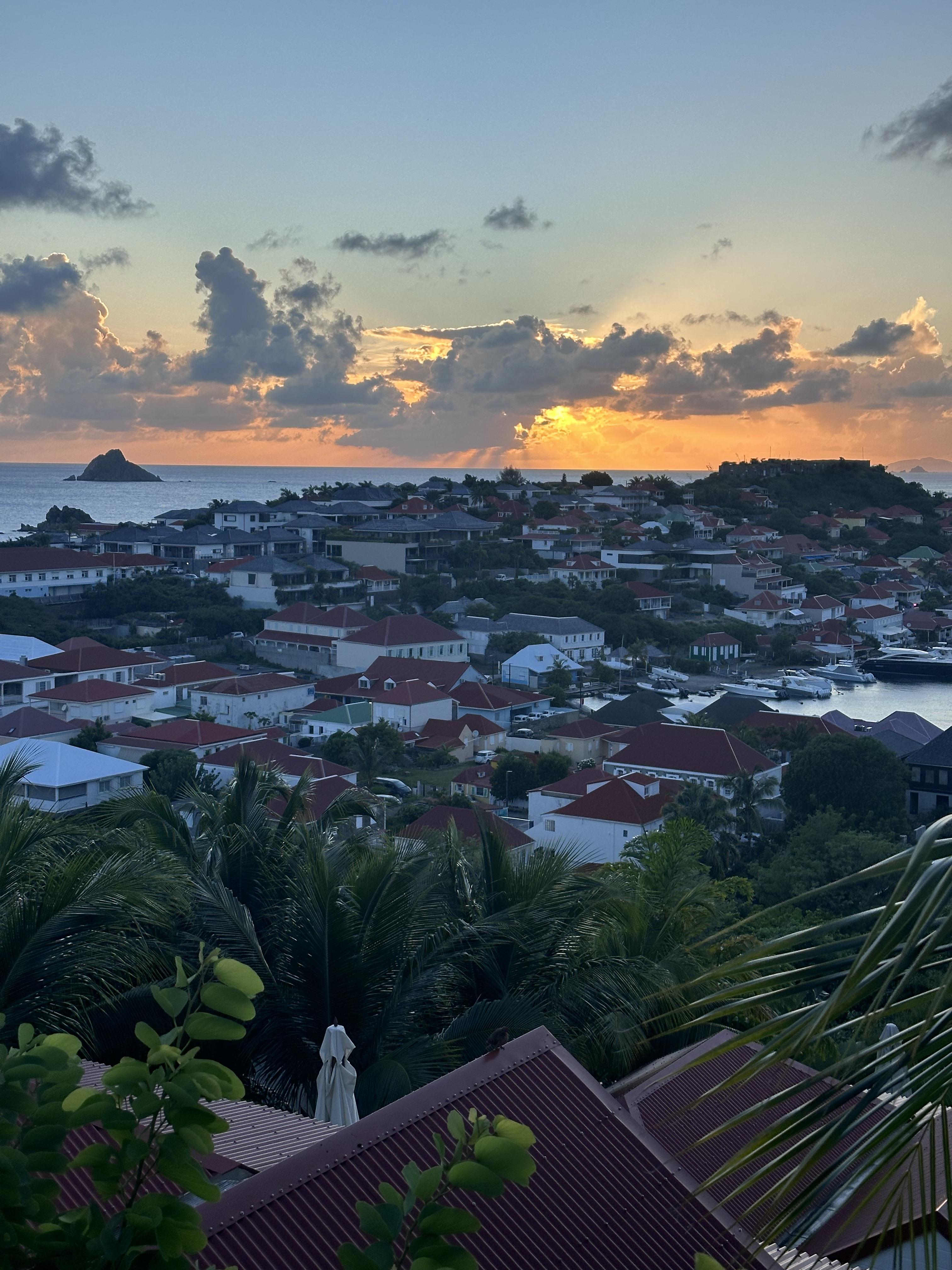 Sunset view from the Columbier Suite at Le Carl Gustaf, St. Barths as the town reaches to the sea.