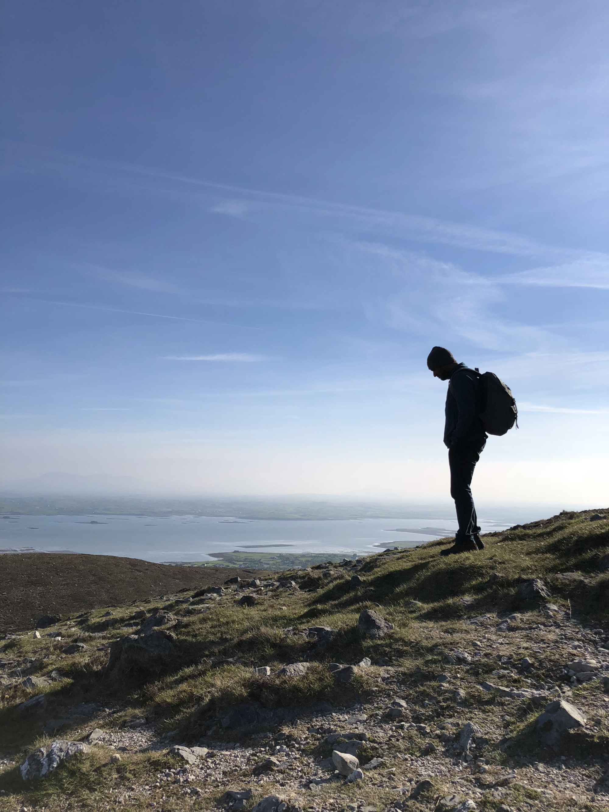 Silhouette of a person on a hiking trail during the daytime