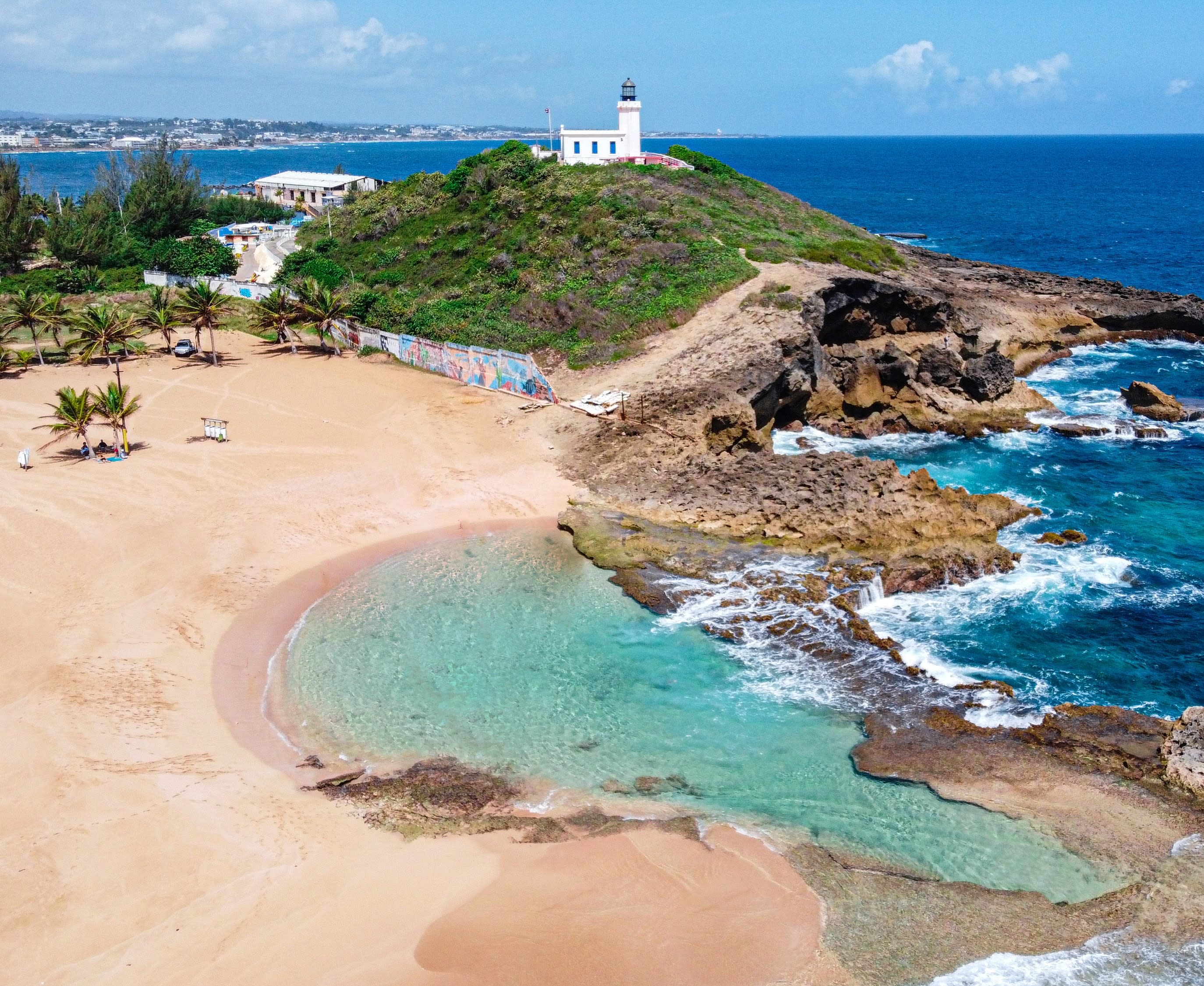 beach and tide pool next to ocean during daytime