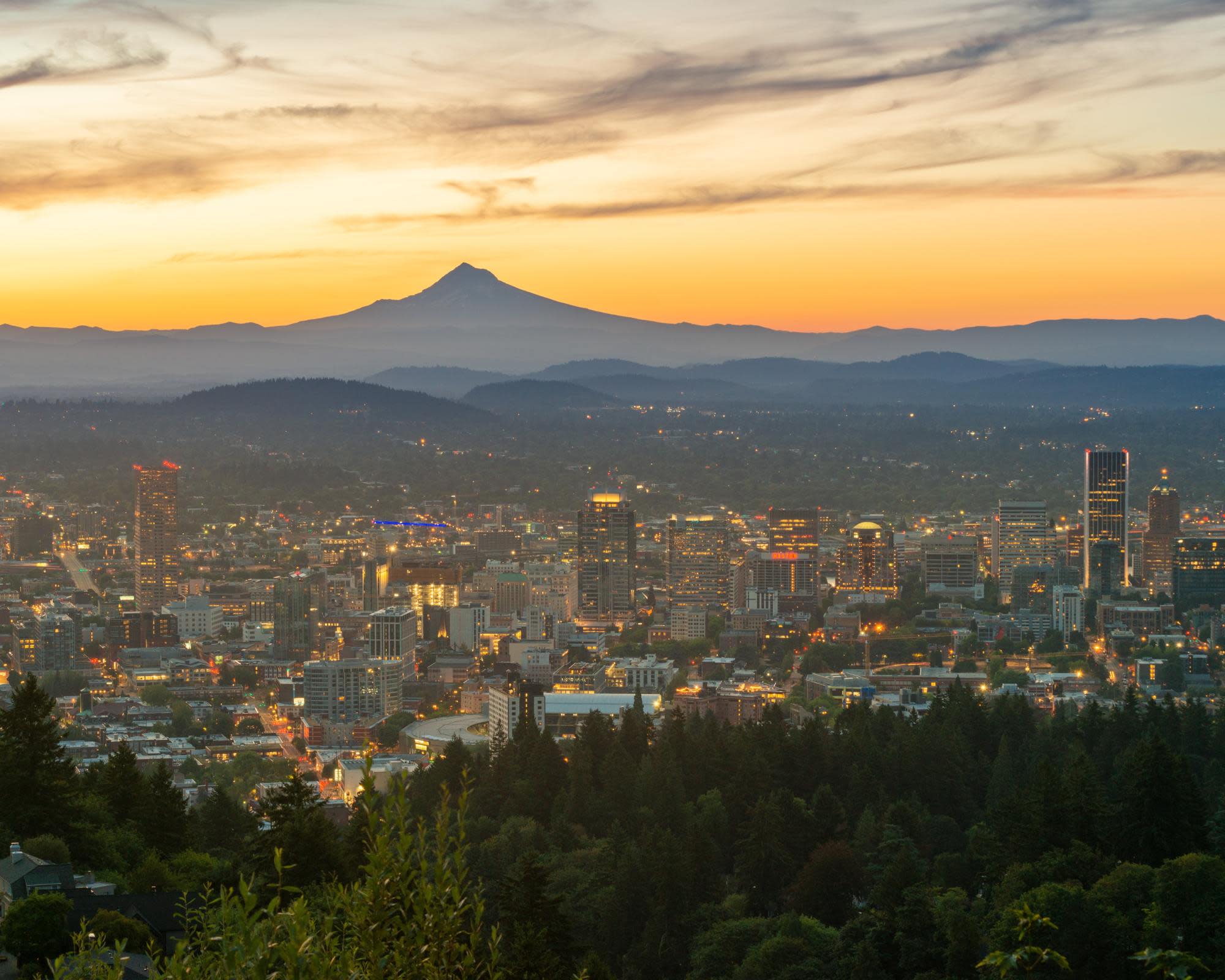 city skyline with mountains during sunset