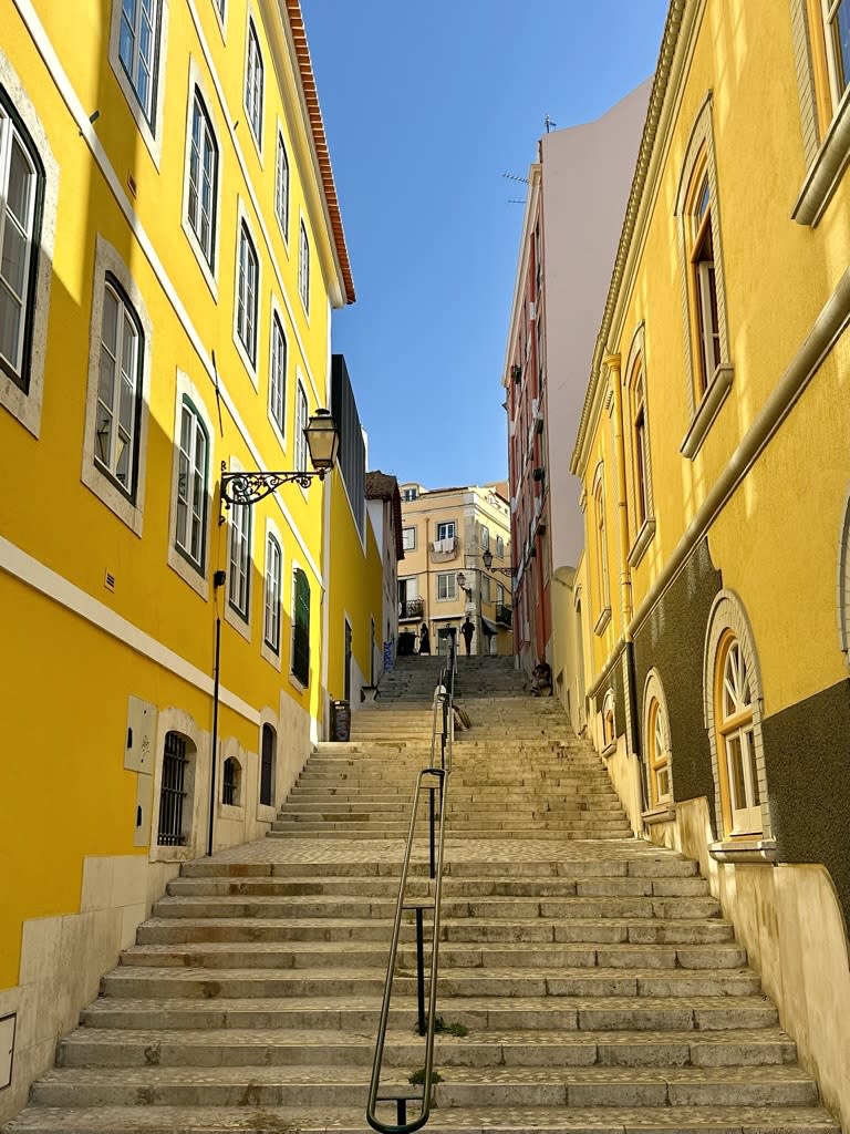Stairs between yellow buildings.