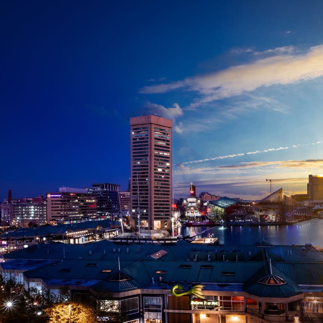 Day to night view of a city harbor.