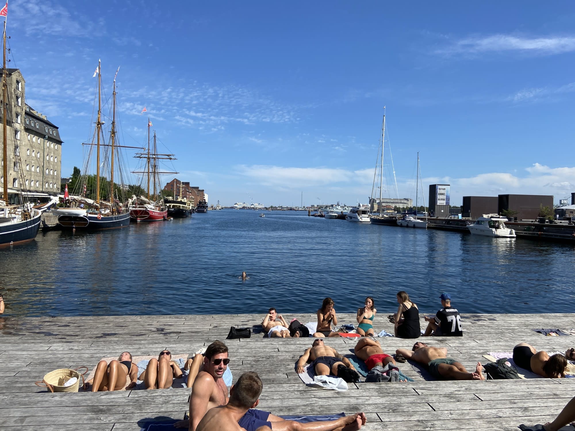 people sun tan on a dock