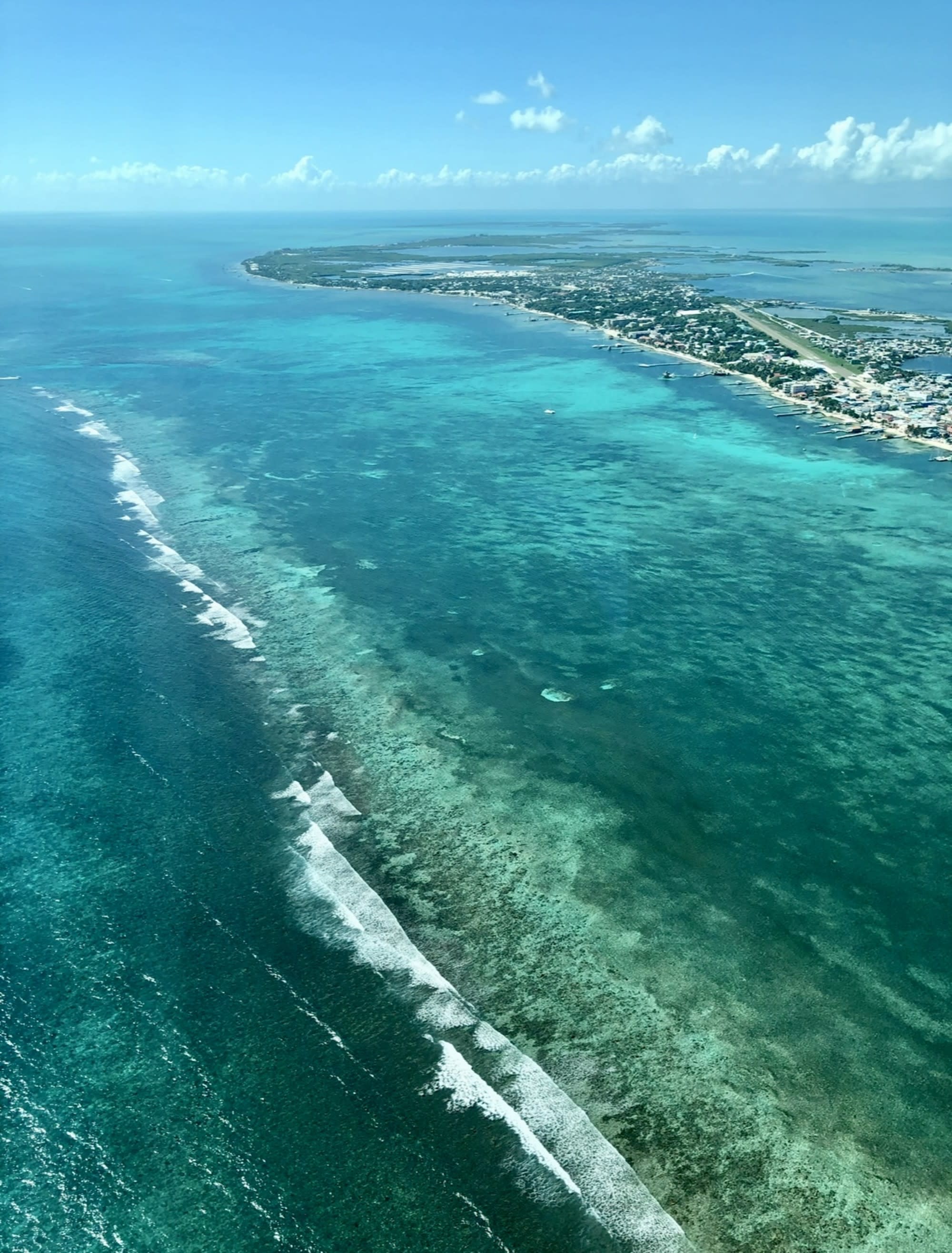 An aerial view of emerald and green-like water on a beautiful day.