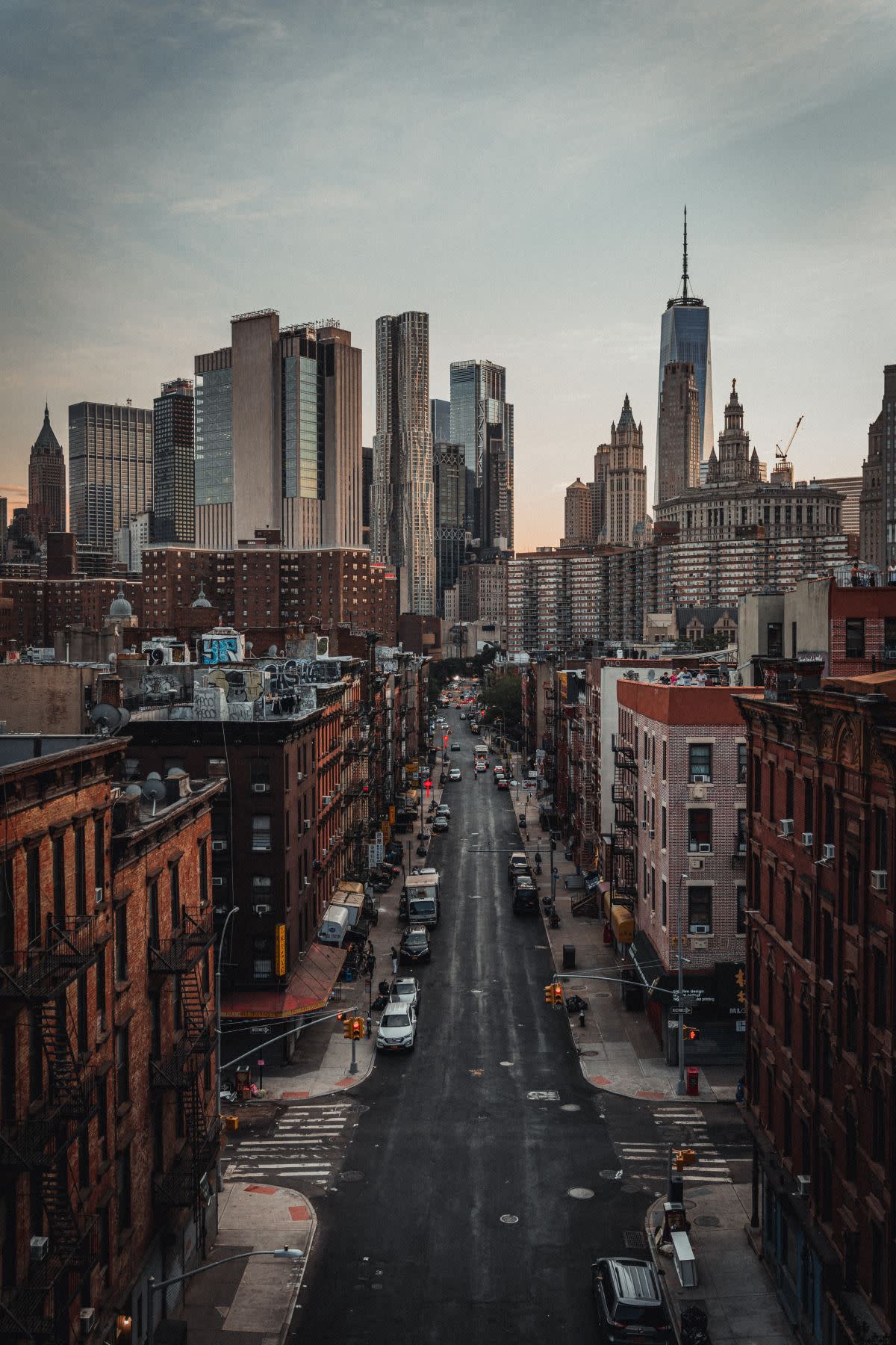 cars parked on a street overlooking New York City's skyline