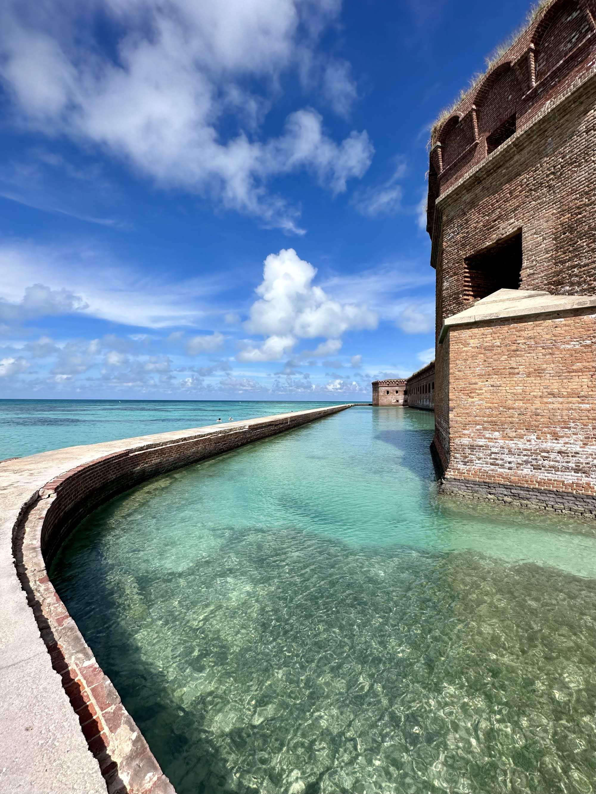 A picture of water near a brown concrete building taken during daytime.
