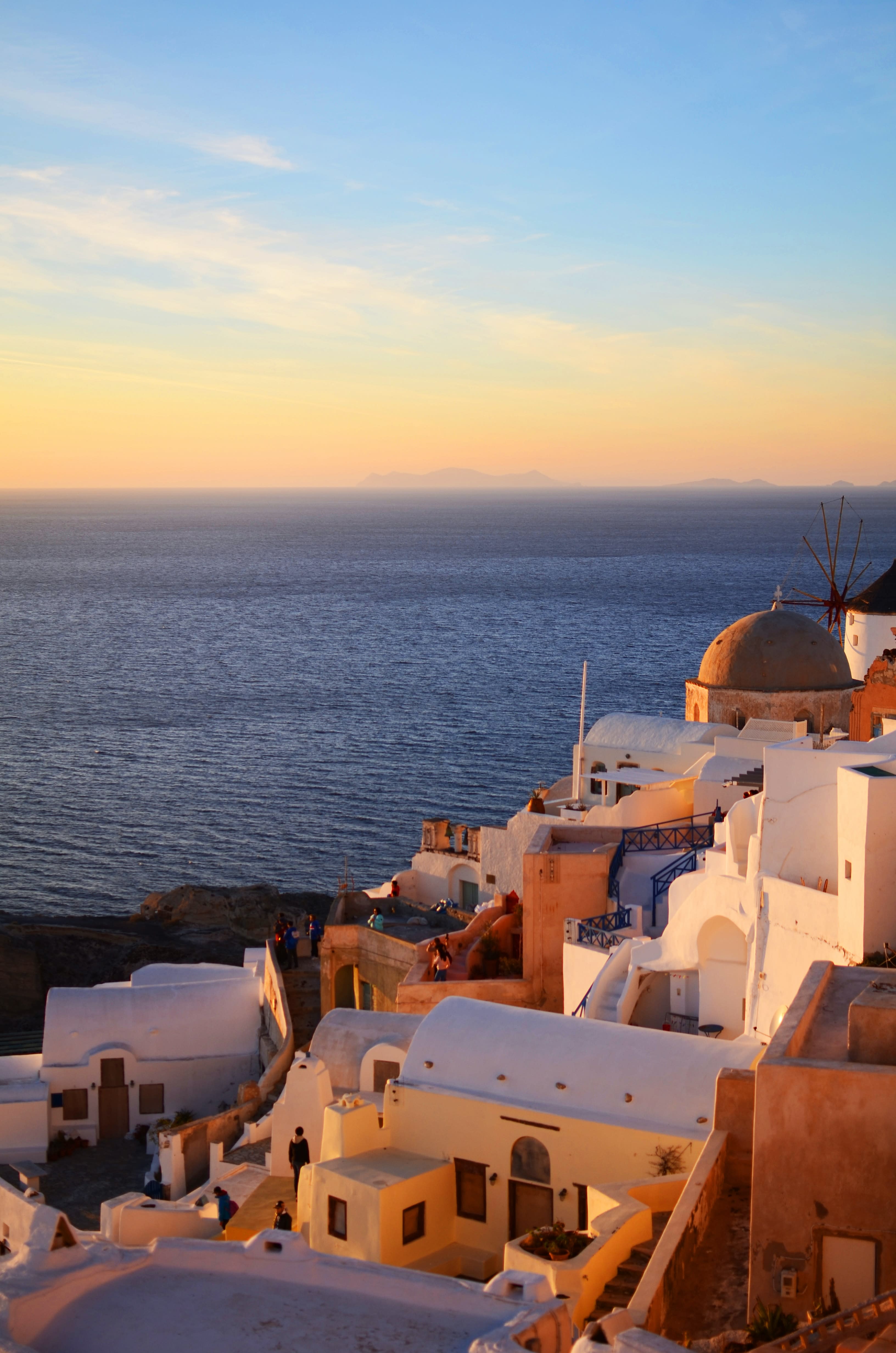 sun setting over the water next to white buildings