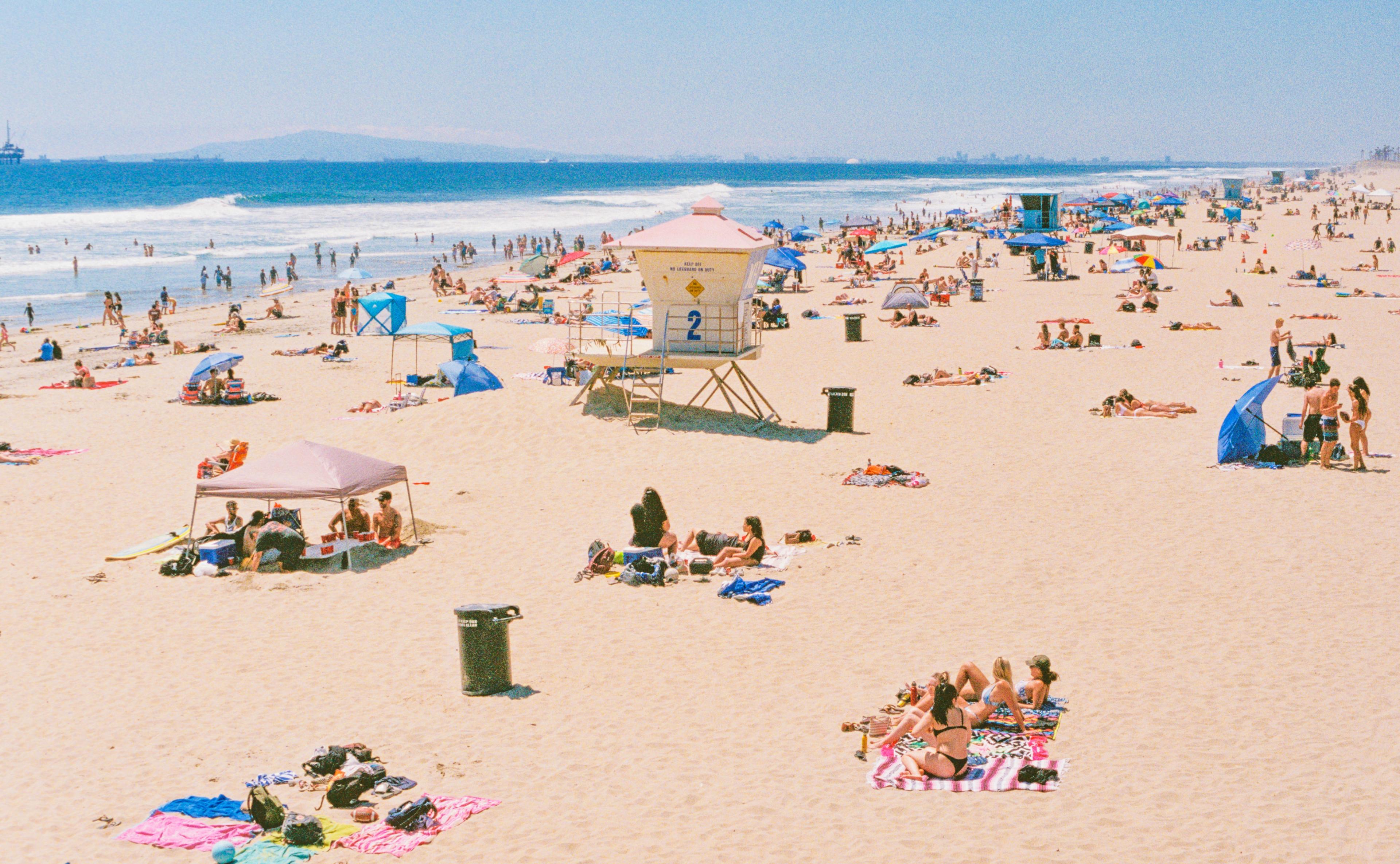 Huntington Beach during day time and people relaxing over there