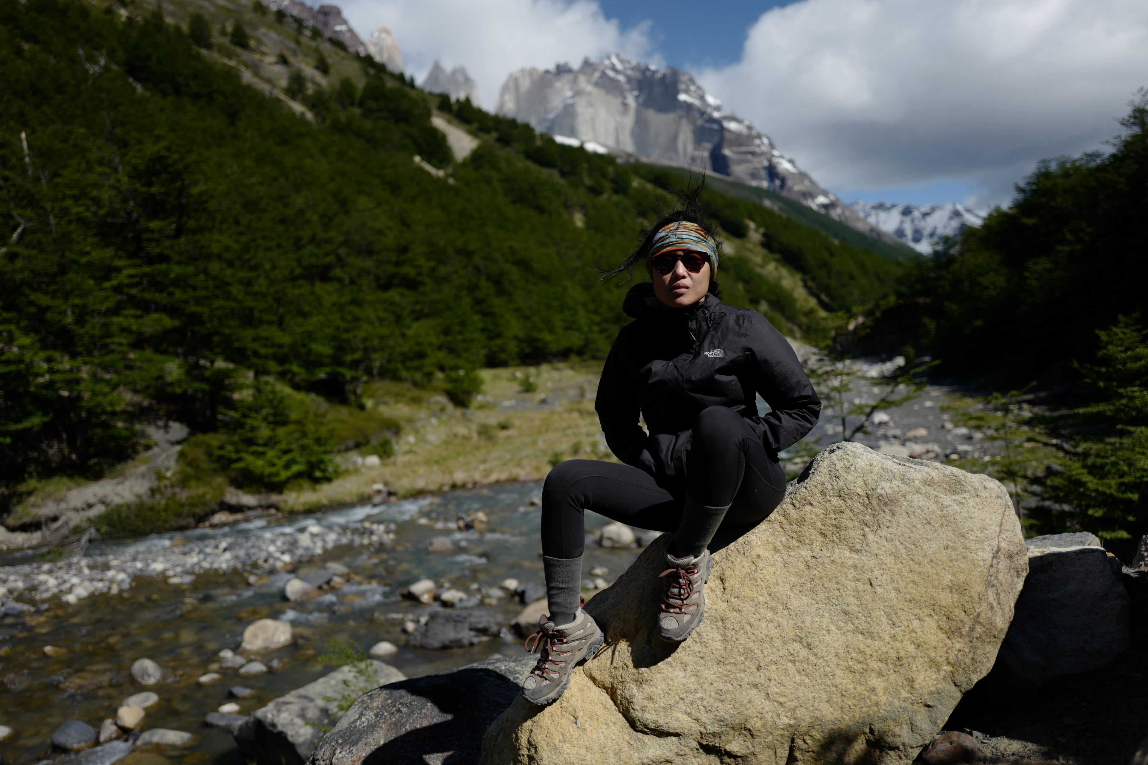 Patagonia person sitting on a rock.